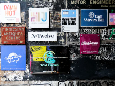 Various signs and posters on a textured wall