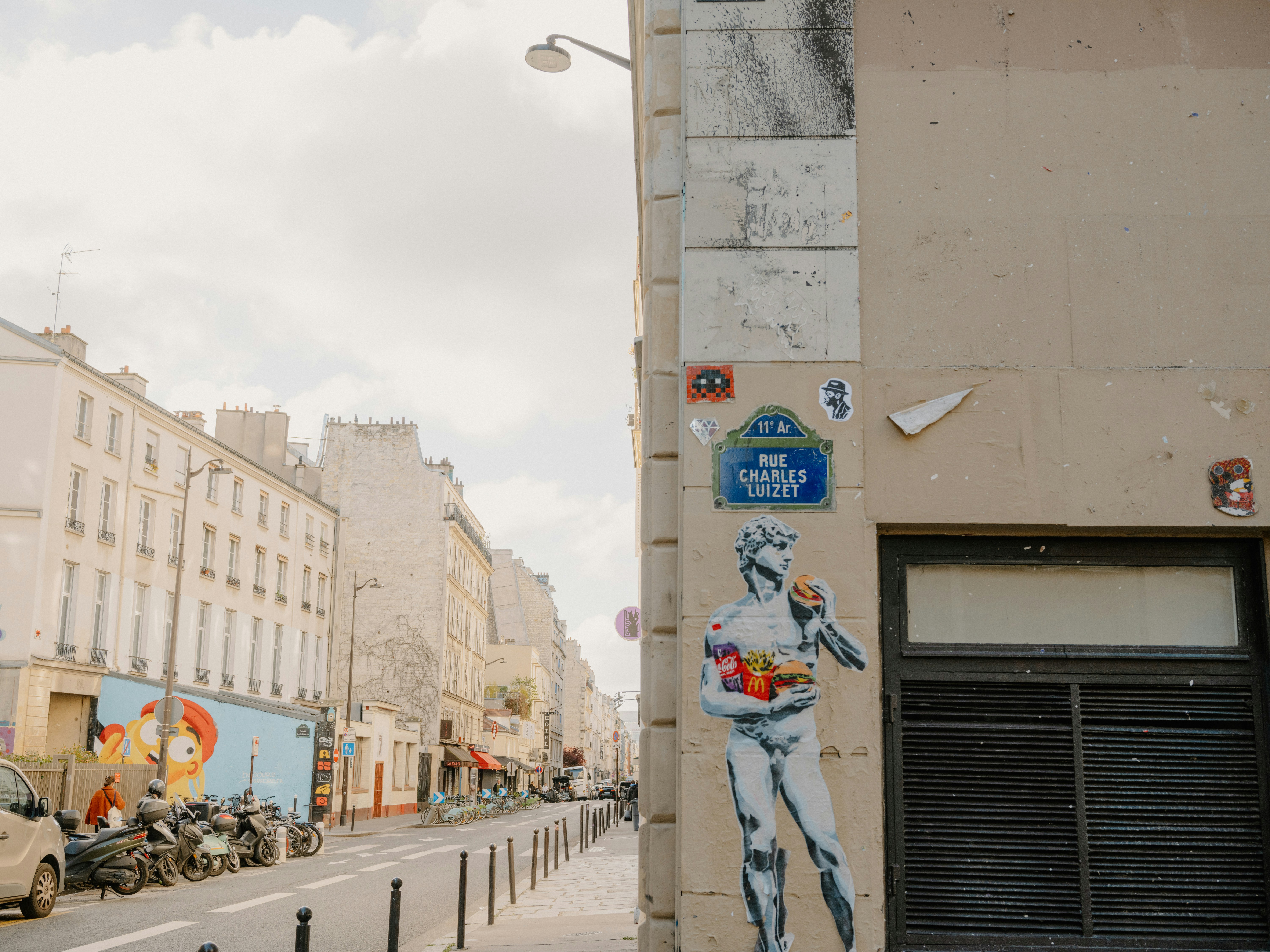 Street art of a statue holding fruit on building