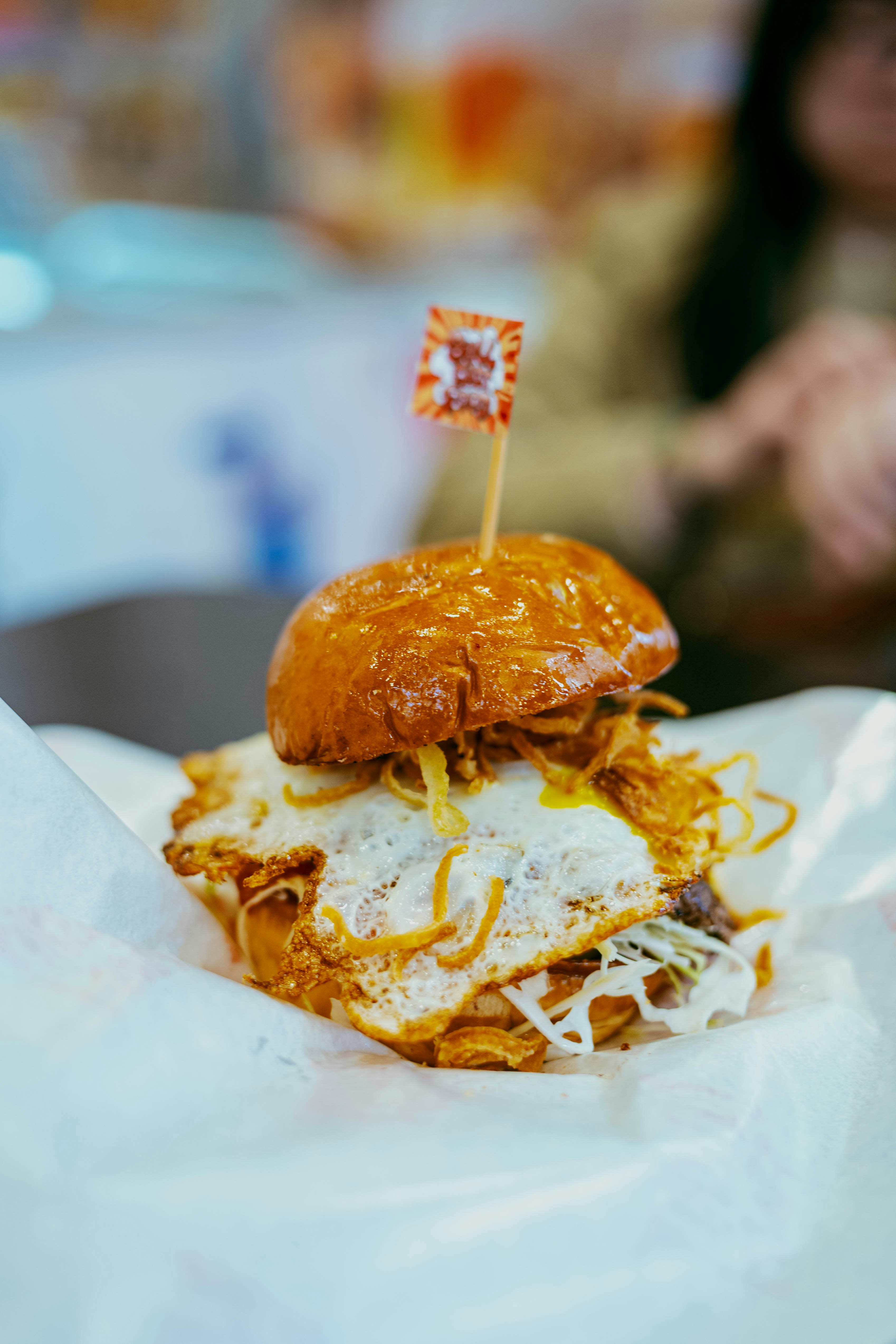 Un delizioso burger con uovo fritto e condimenti croccanti
