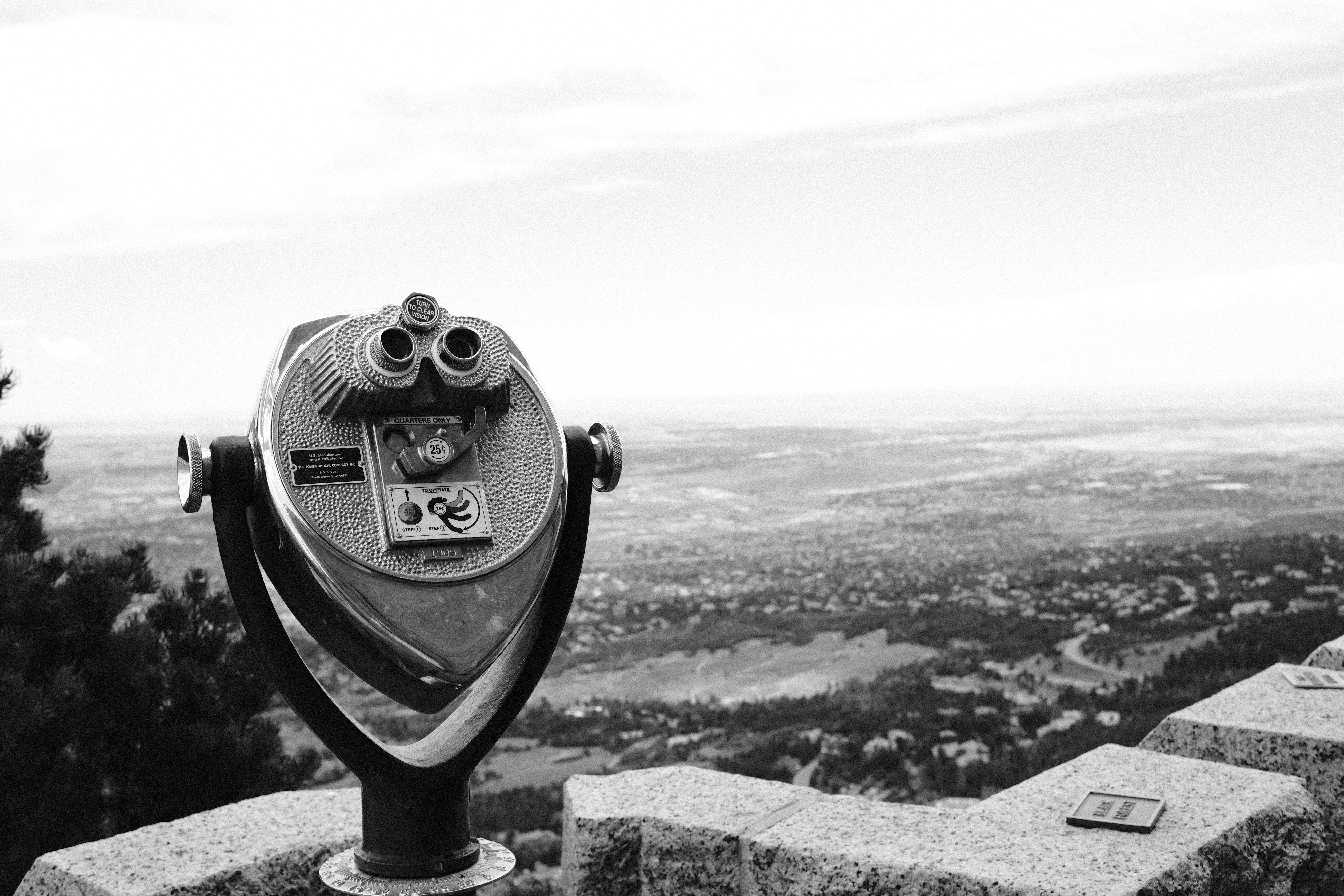 Binoculars on a stone wall overlooking a valley