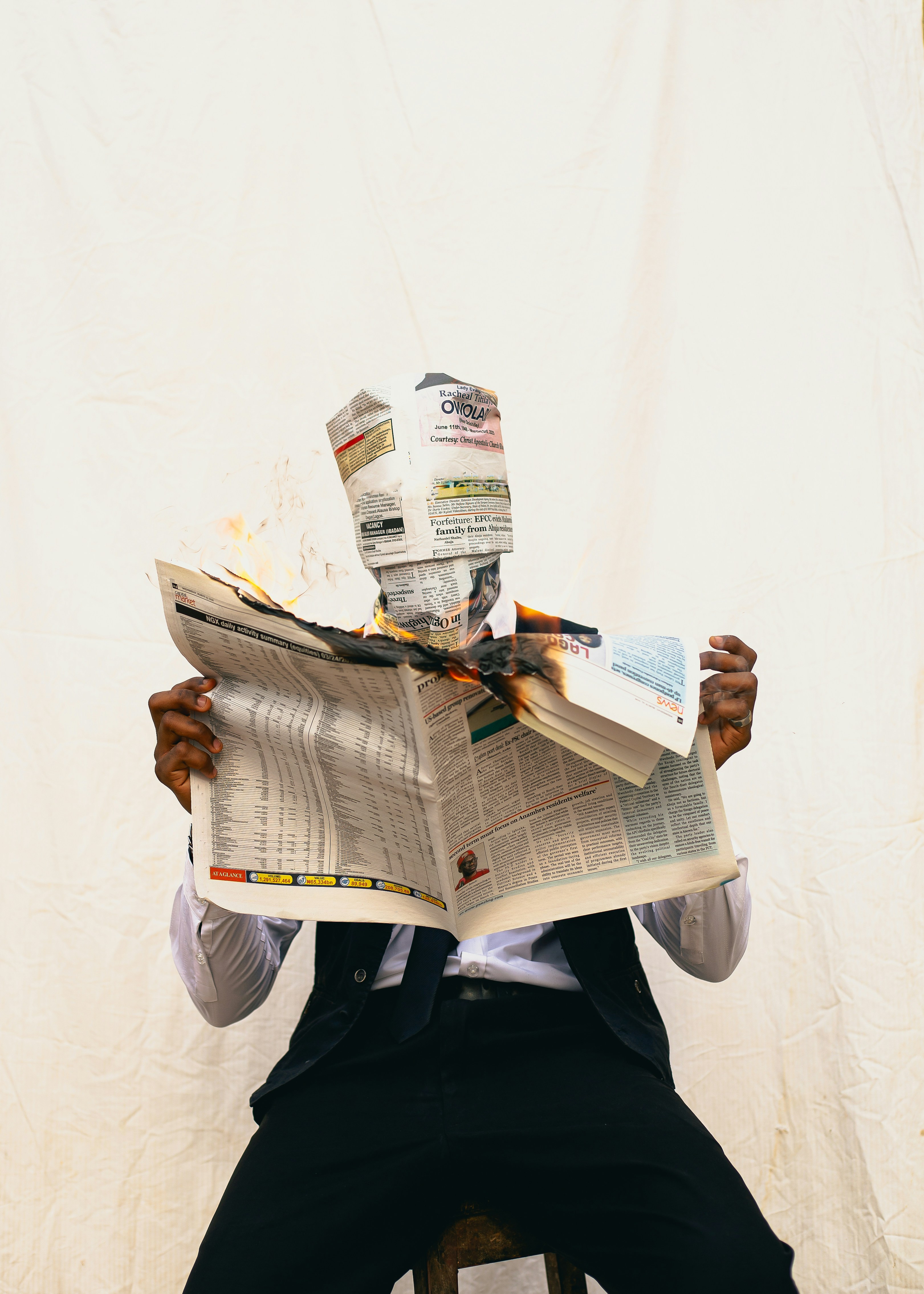 Person with newspaper burning over head