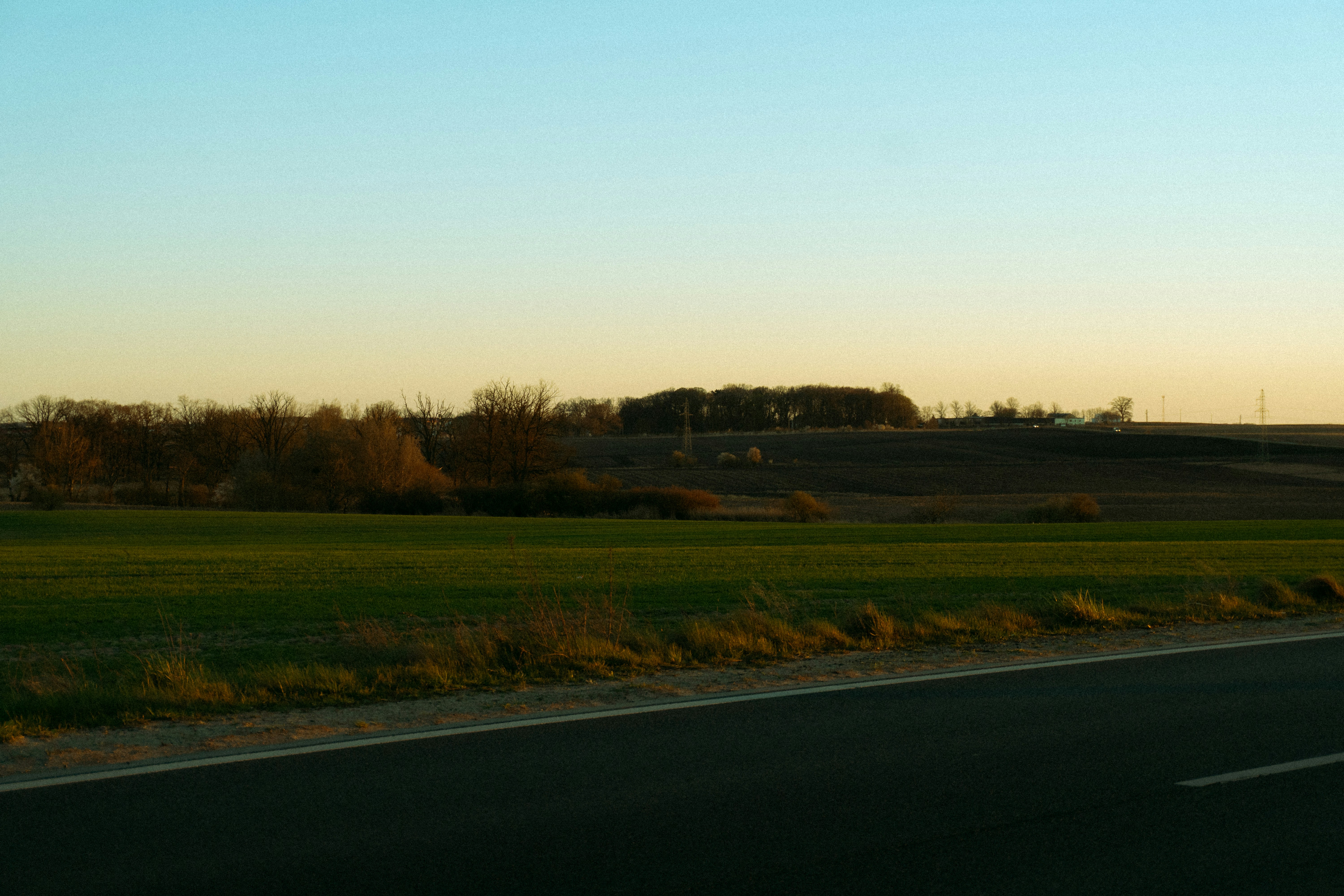 Rural landscape with fields and trees at sunset.
