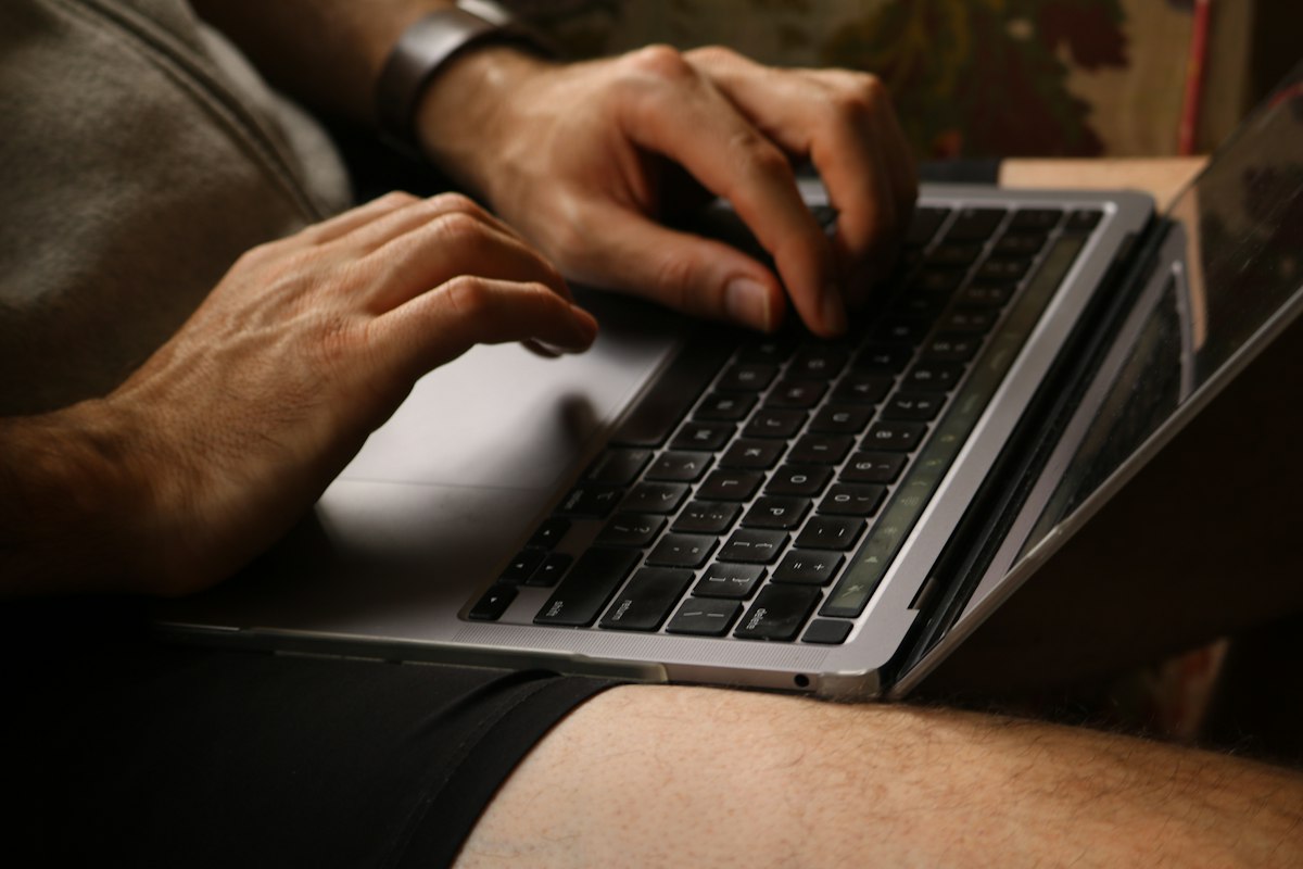 A person typing on a laptop computer keyboard at a desk while evaluating typing speed and comfort