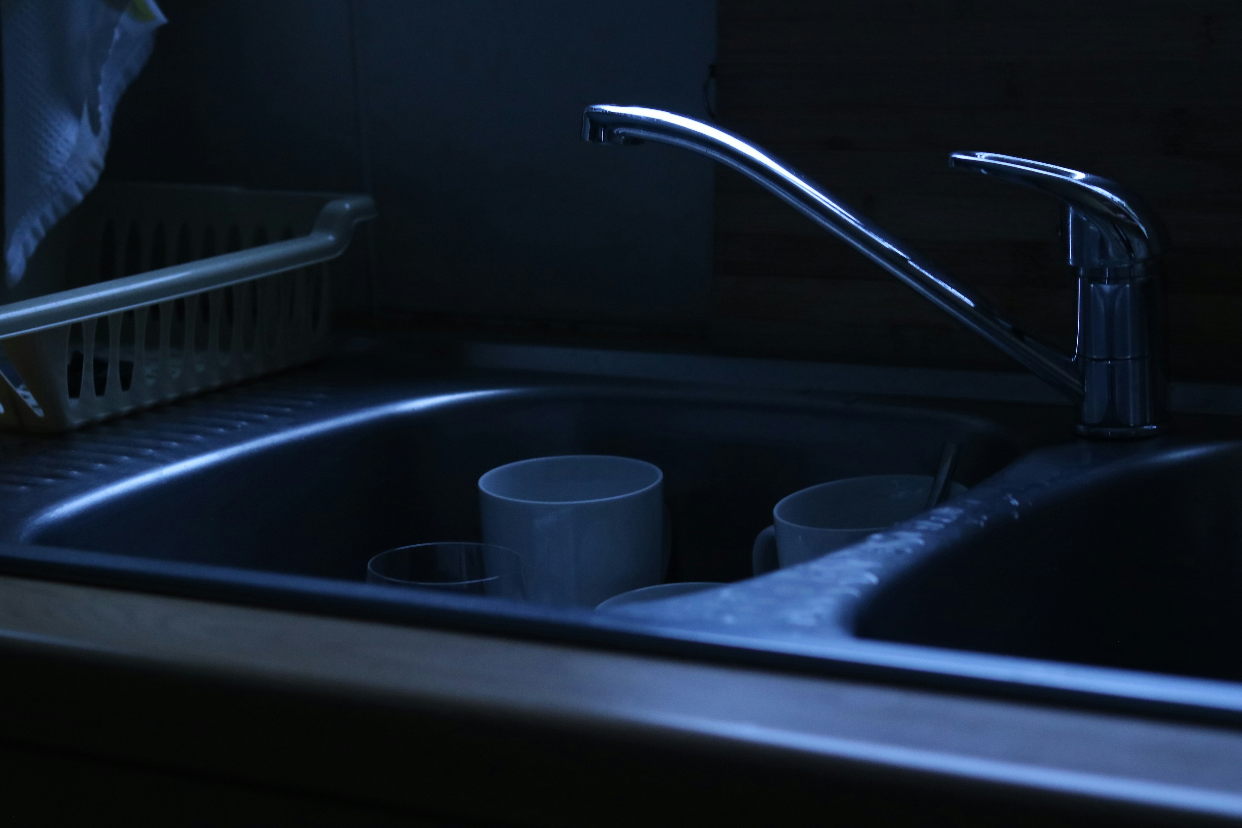 Dirty dishes in a dark kitchen sink