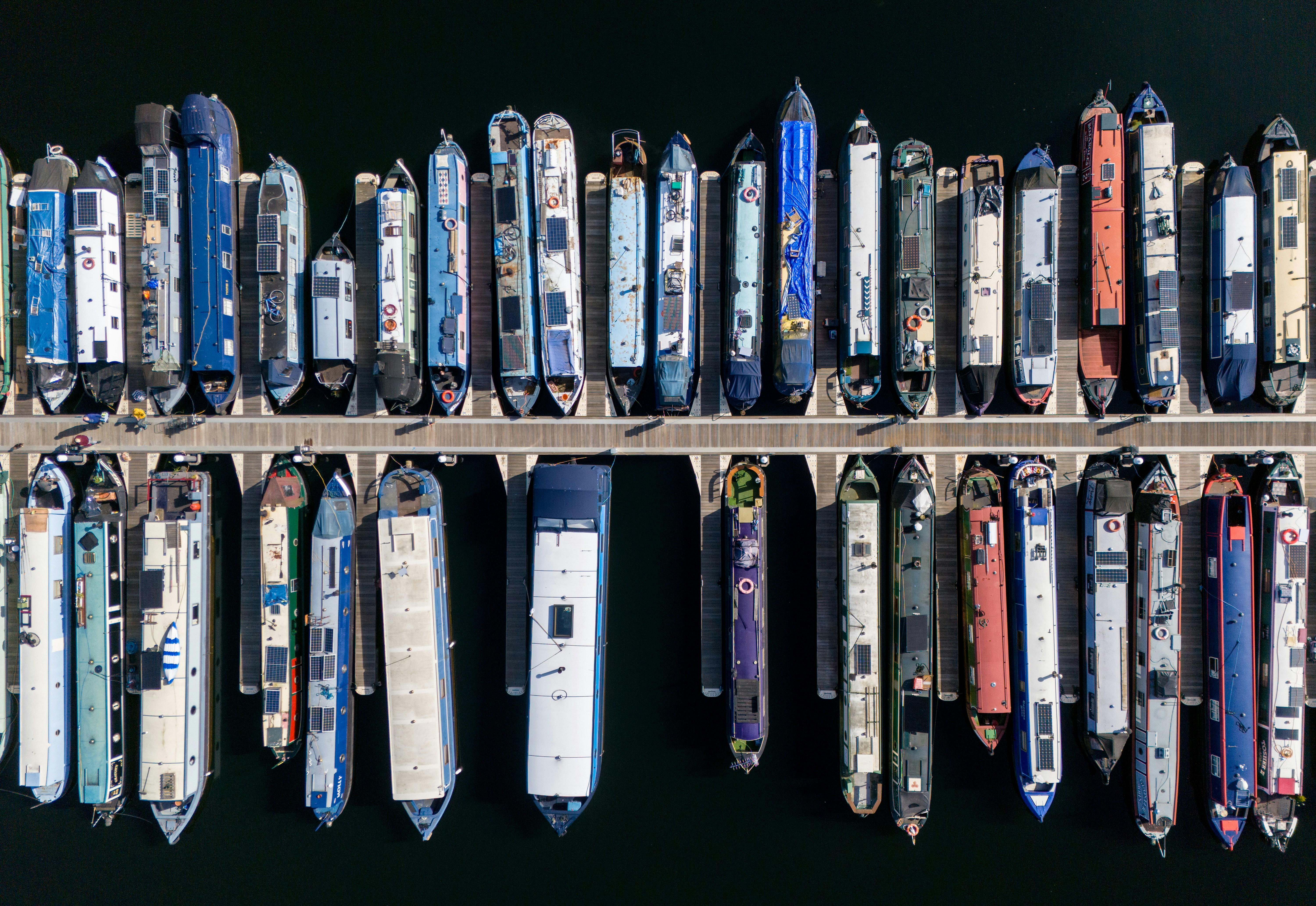 Muitos barcos atracaram em um porto, visto de cima.