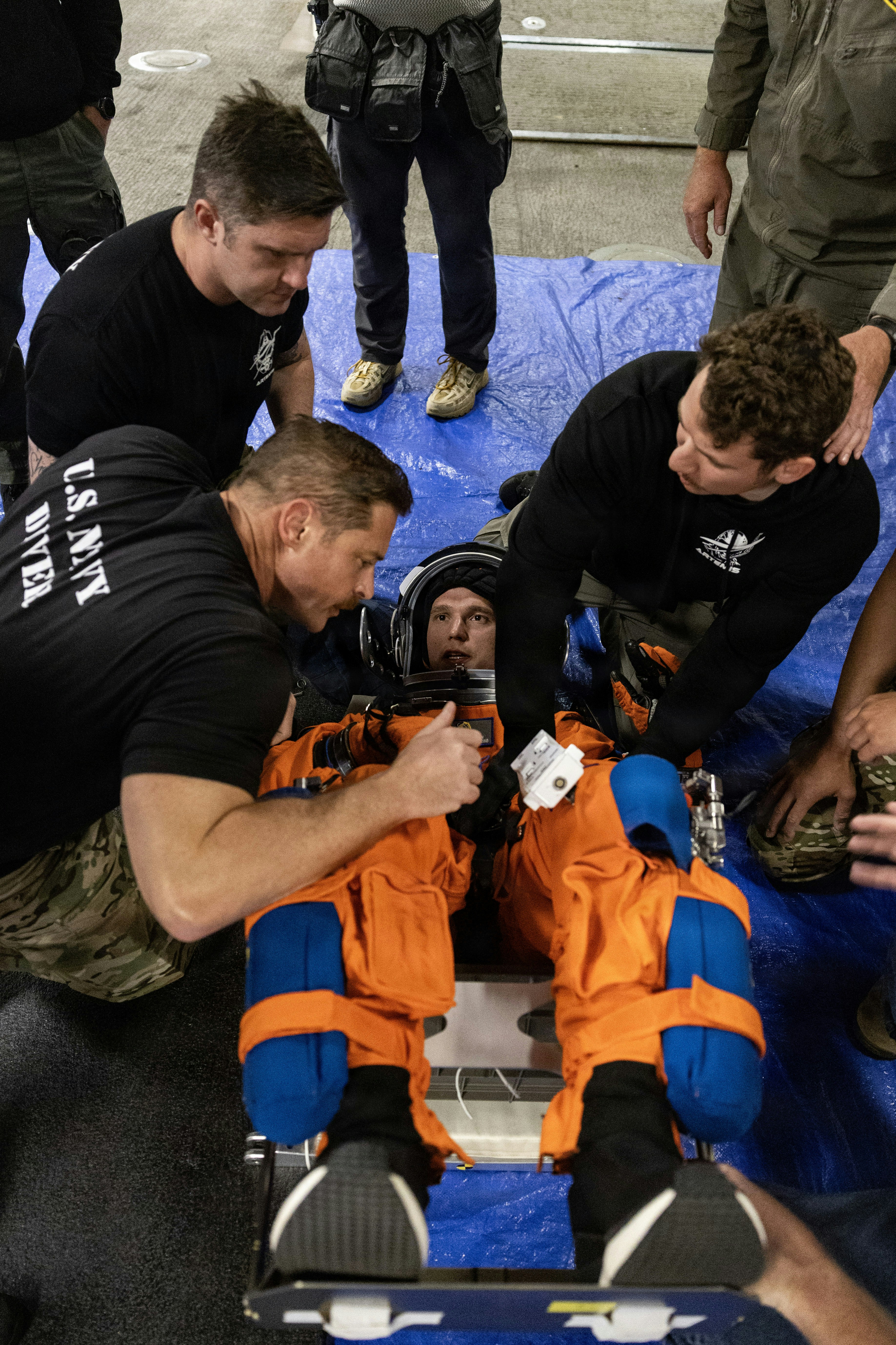 Astronaut wird von der Crew auf eine Trage gebracht.