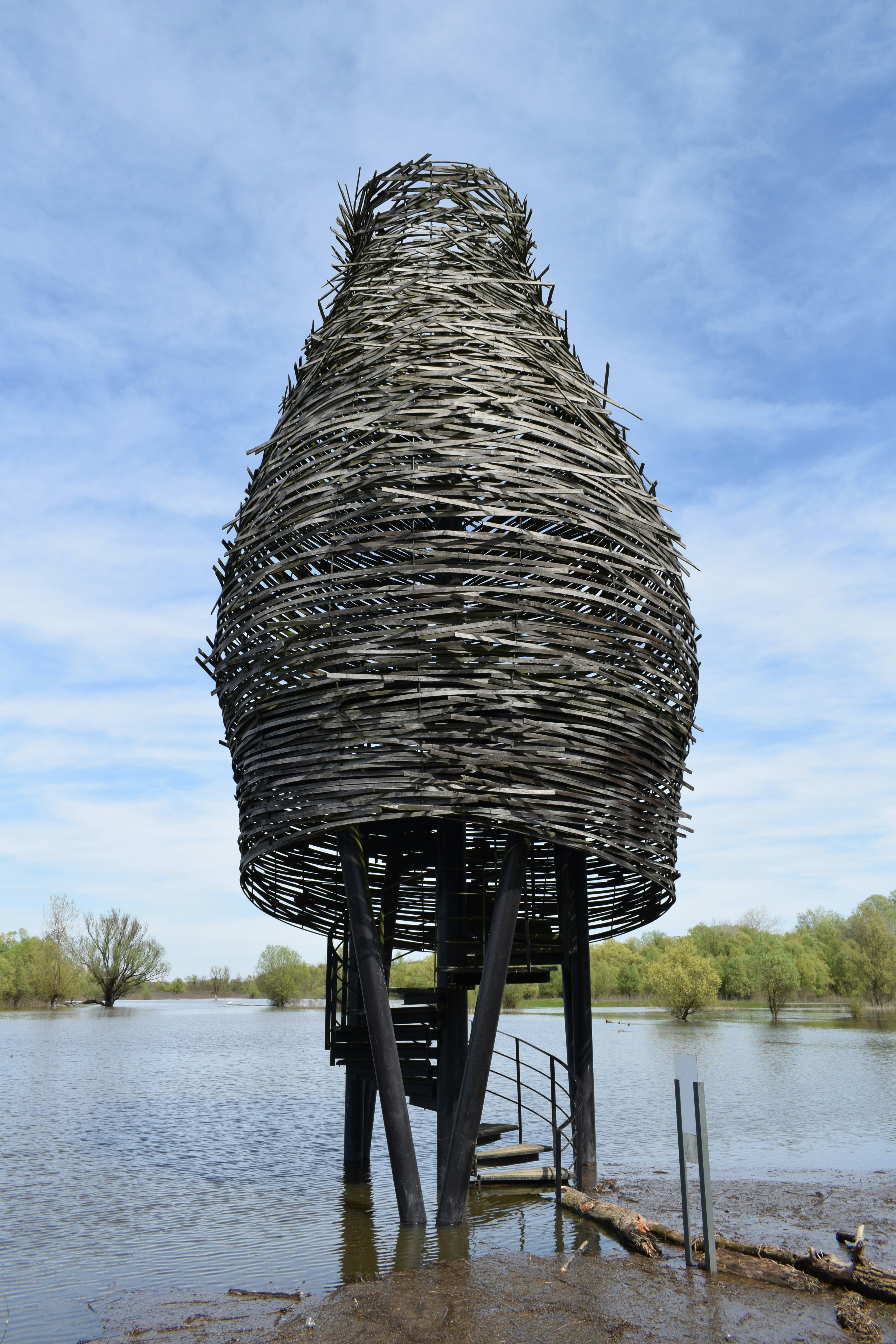 Tall woven structure on stilts in water
