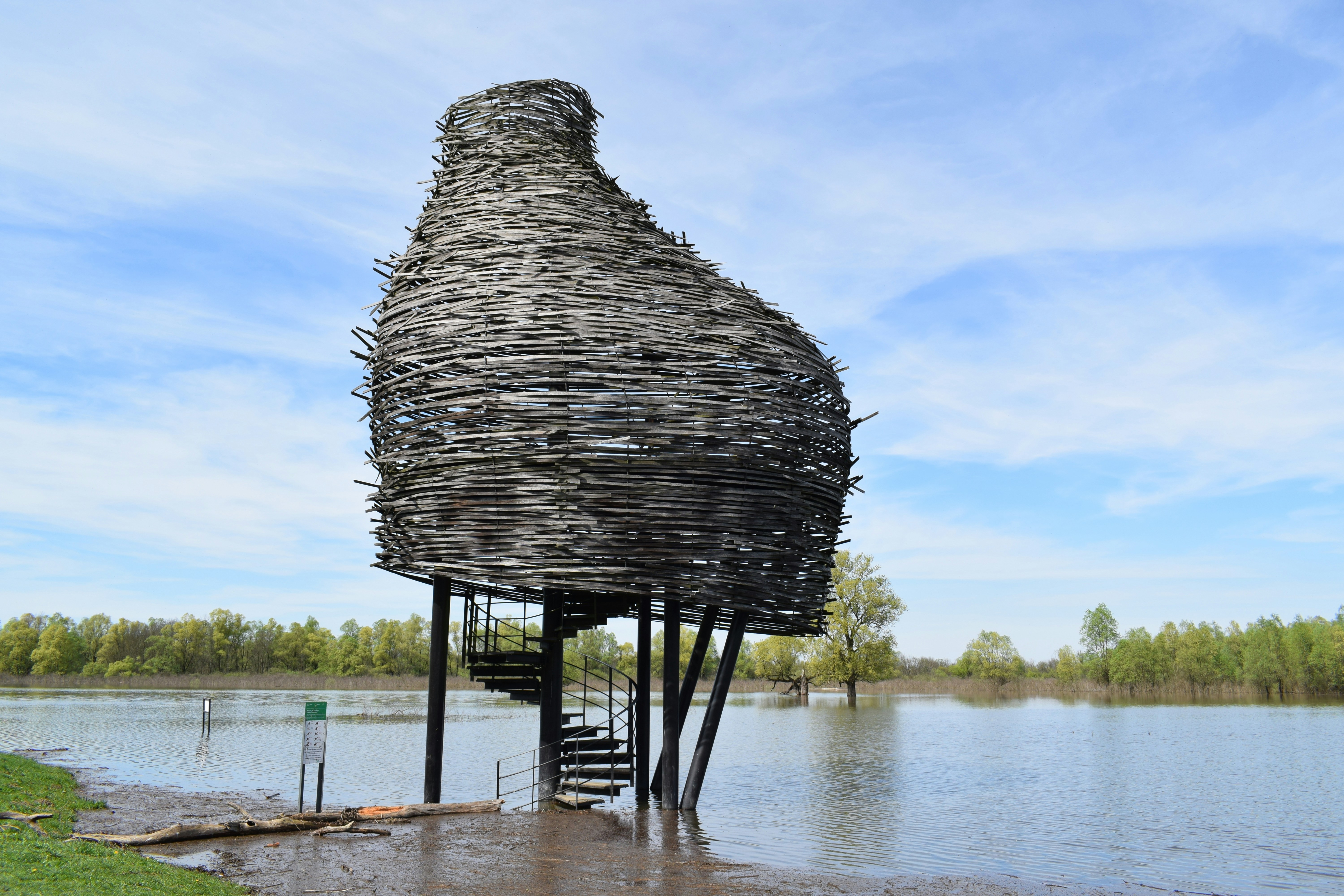 Unusual bird-shaped structure on stilts in flooded landscape