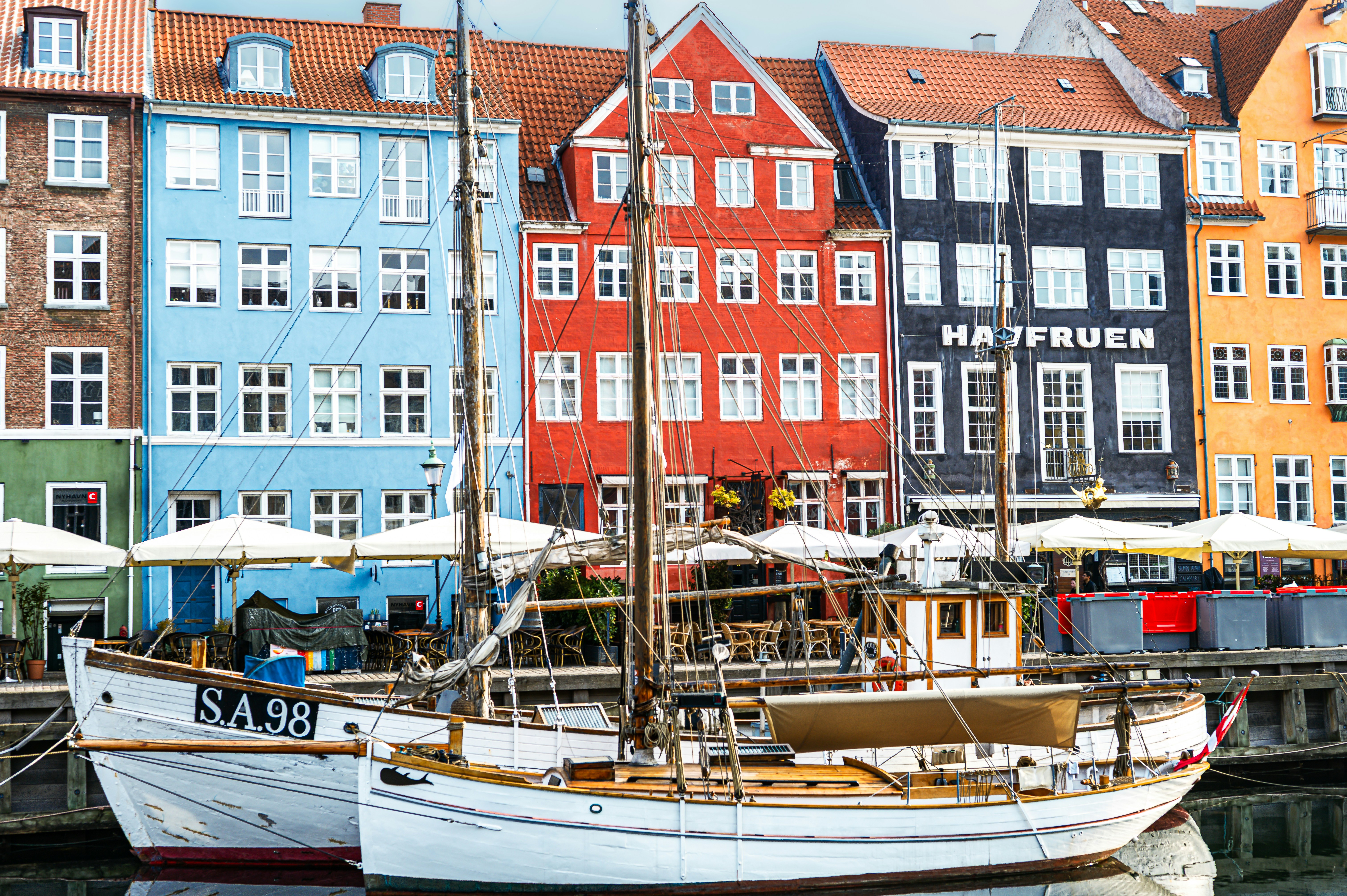 Colorful buildings line a canal with boats.
