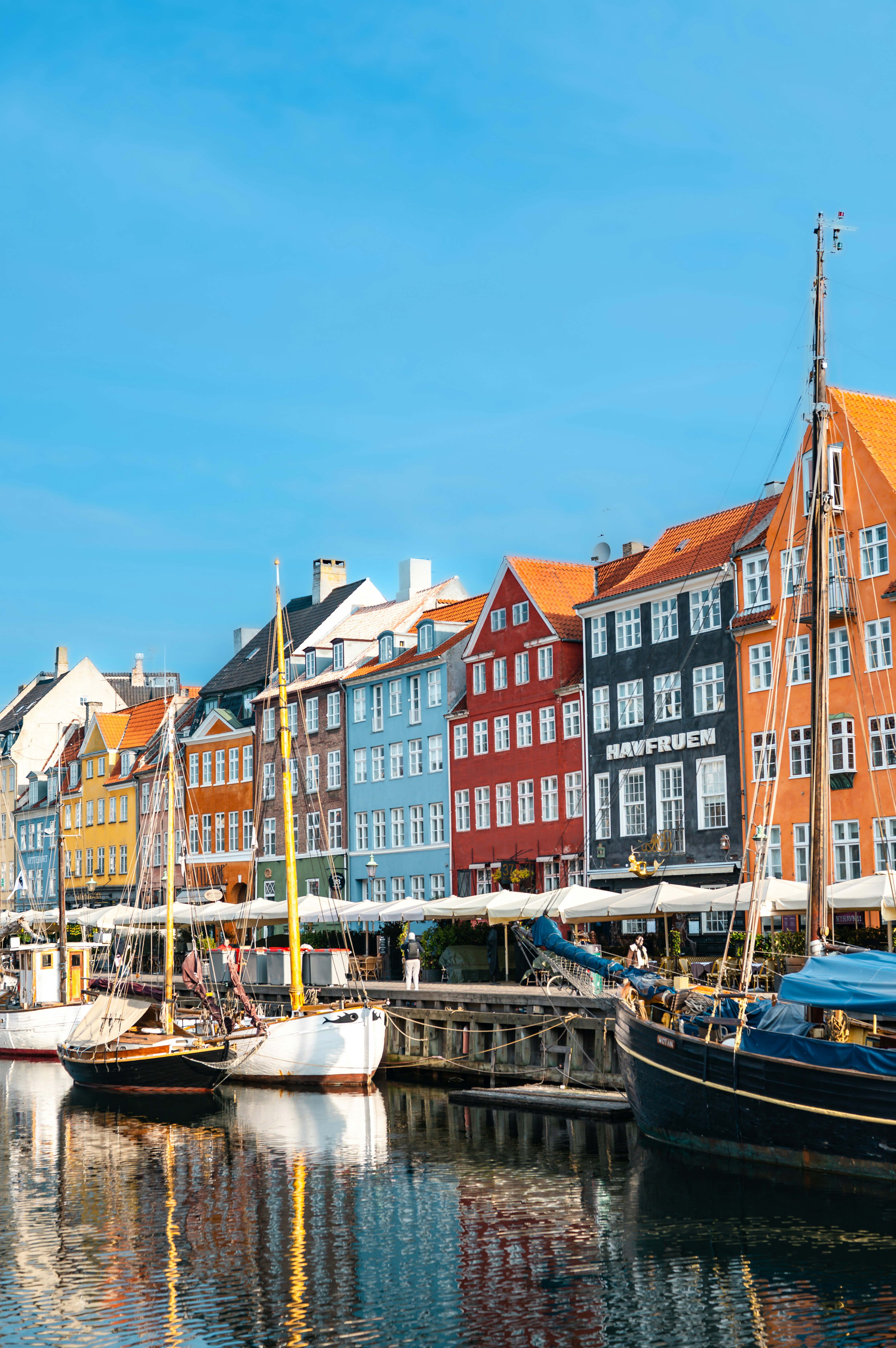 Colorful facades line the Nyhavn canal in Copenhagen, Denmark, creating a lively waterfront scene.