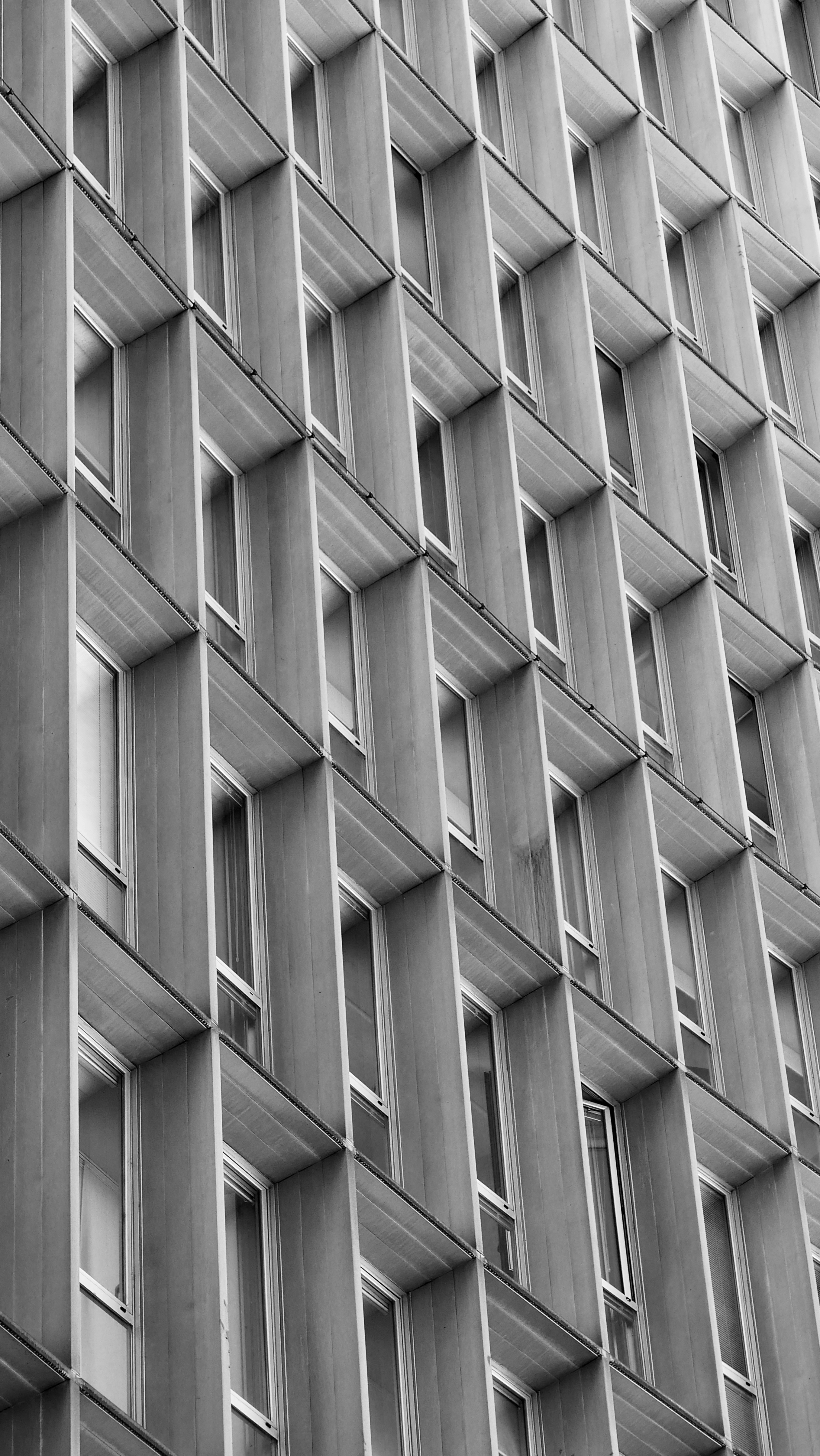 Facciata geometrica di un edificio moderno con finestre ripetute.