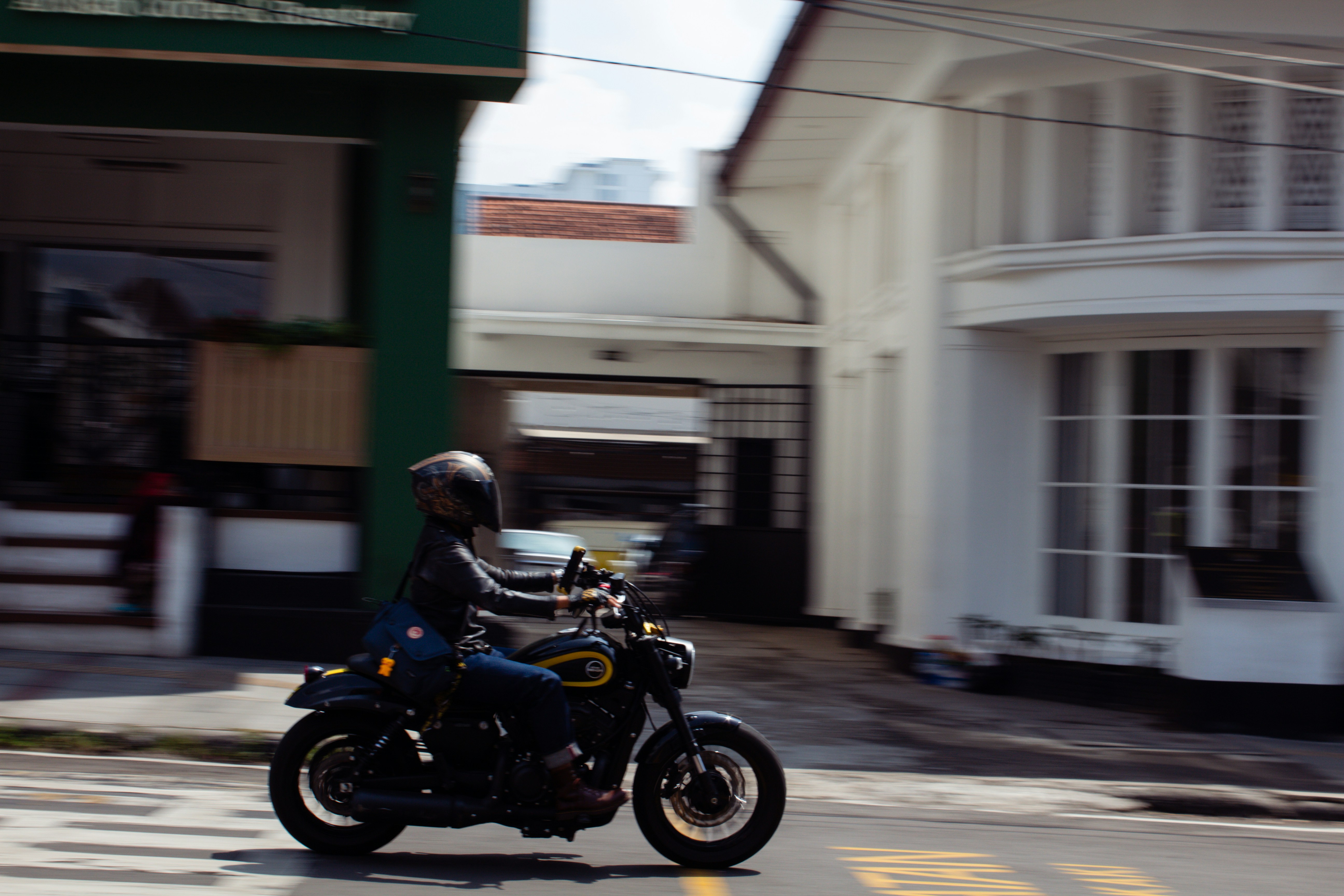 Person riding a motorcycle down a street