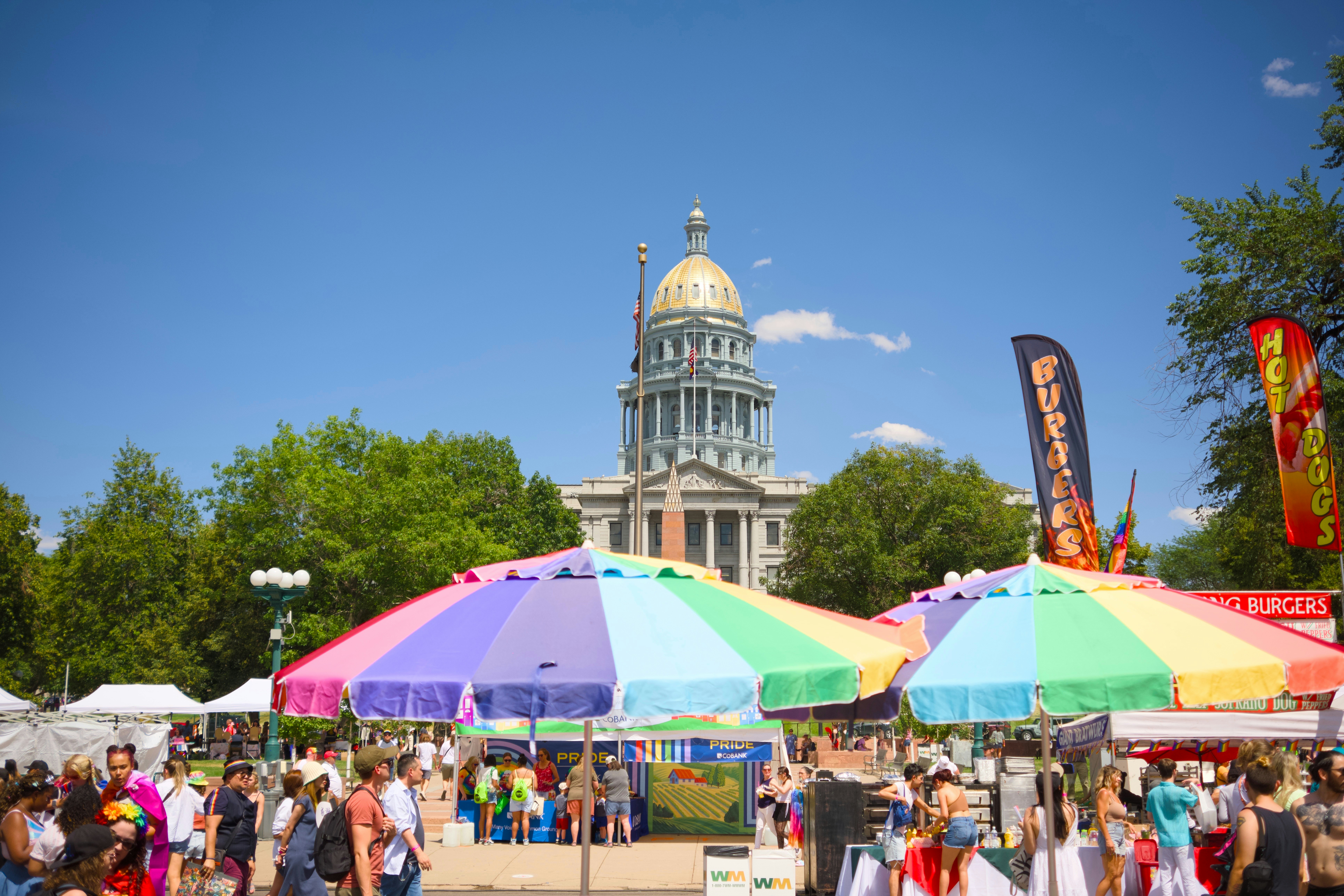 Outdoor festival with colorful umbrellas and a building.