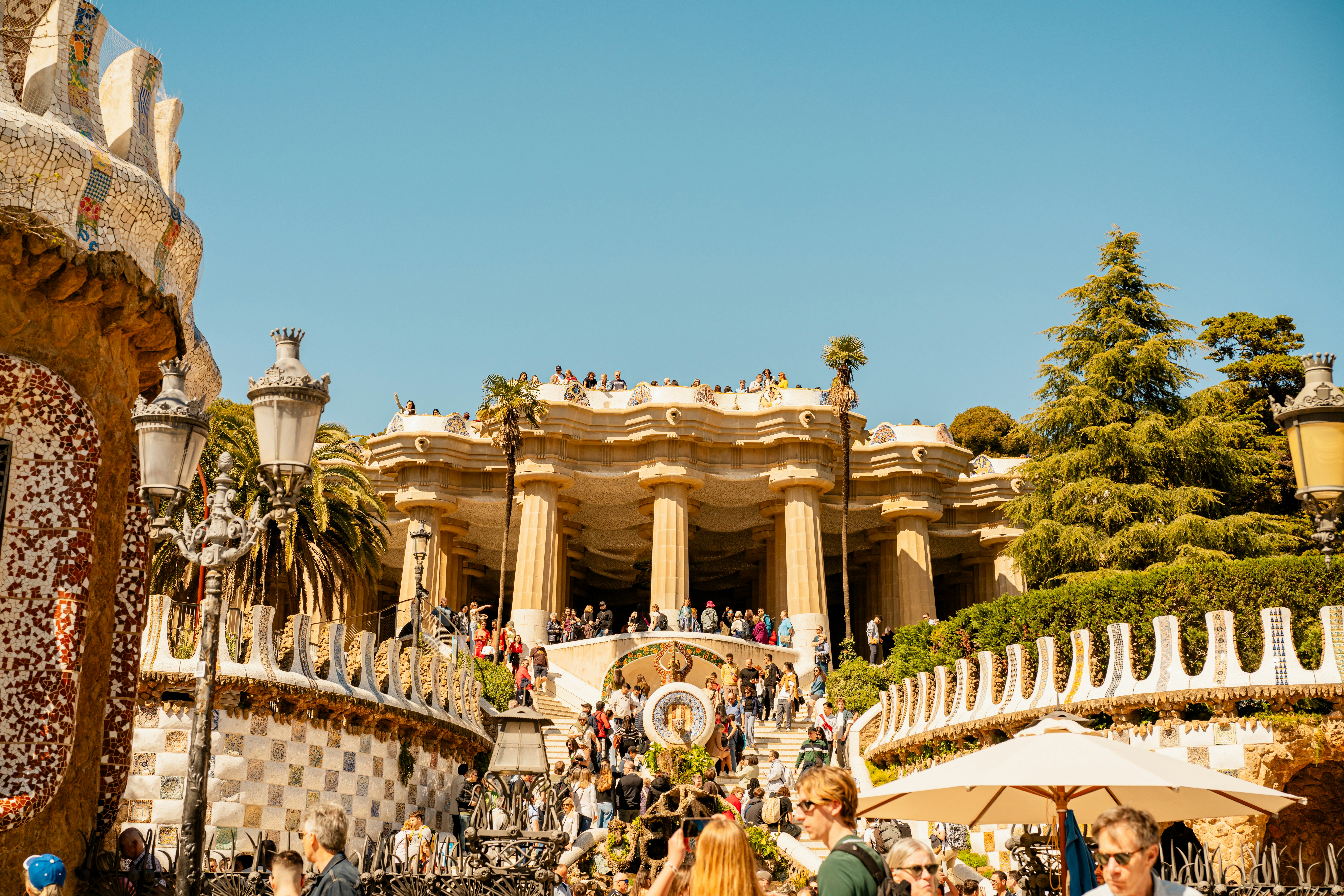 バルセロナのグエル公園では、人々が華やかな階段を上ります。