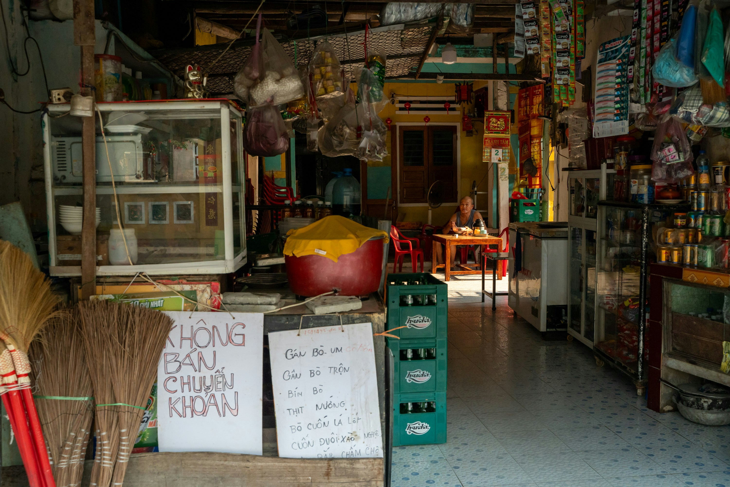 Ein überfülltes Schaufenster mit Waren und Schildern, sichtbare Beschilderung.