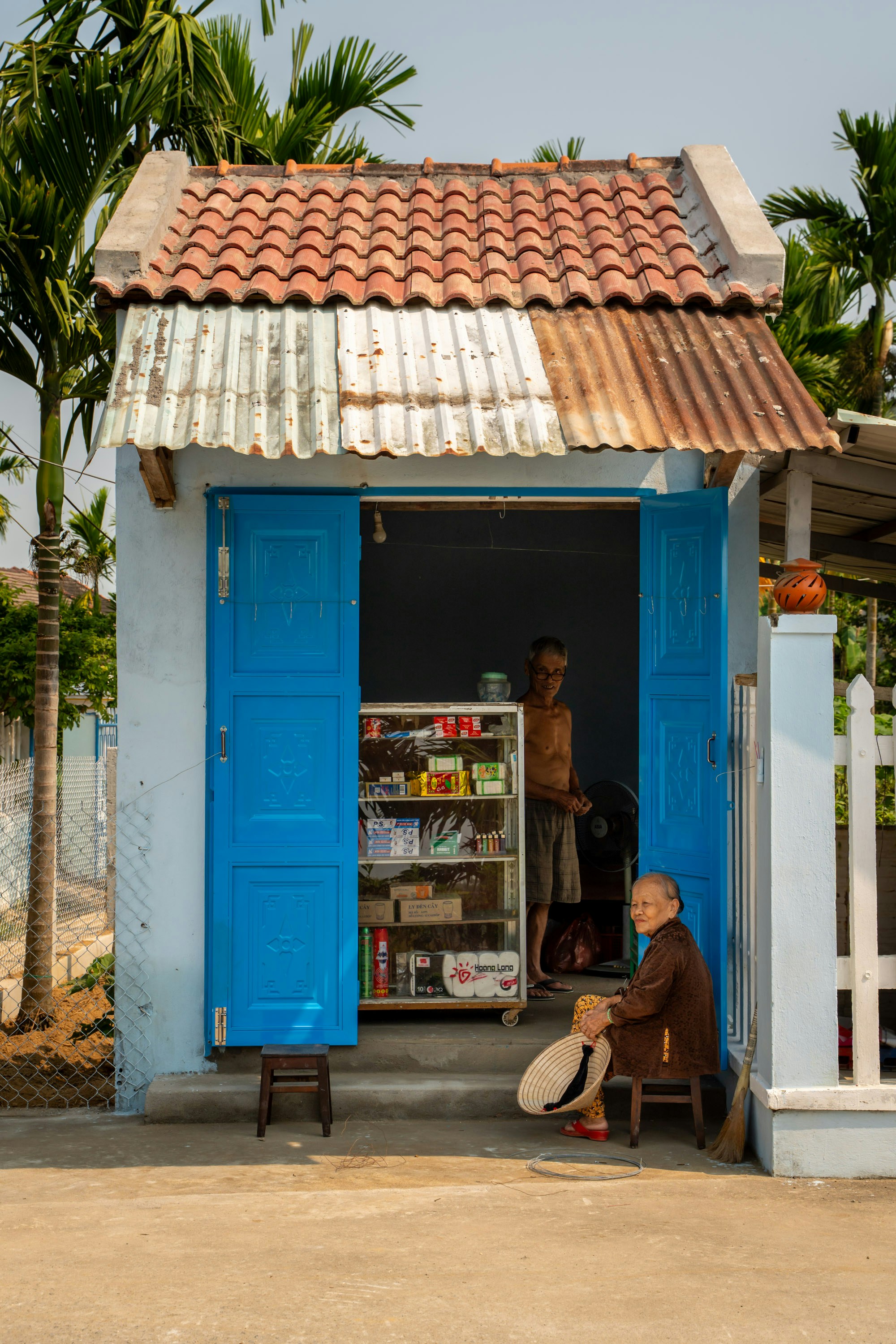 Elderly people sitting outside a small village shop