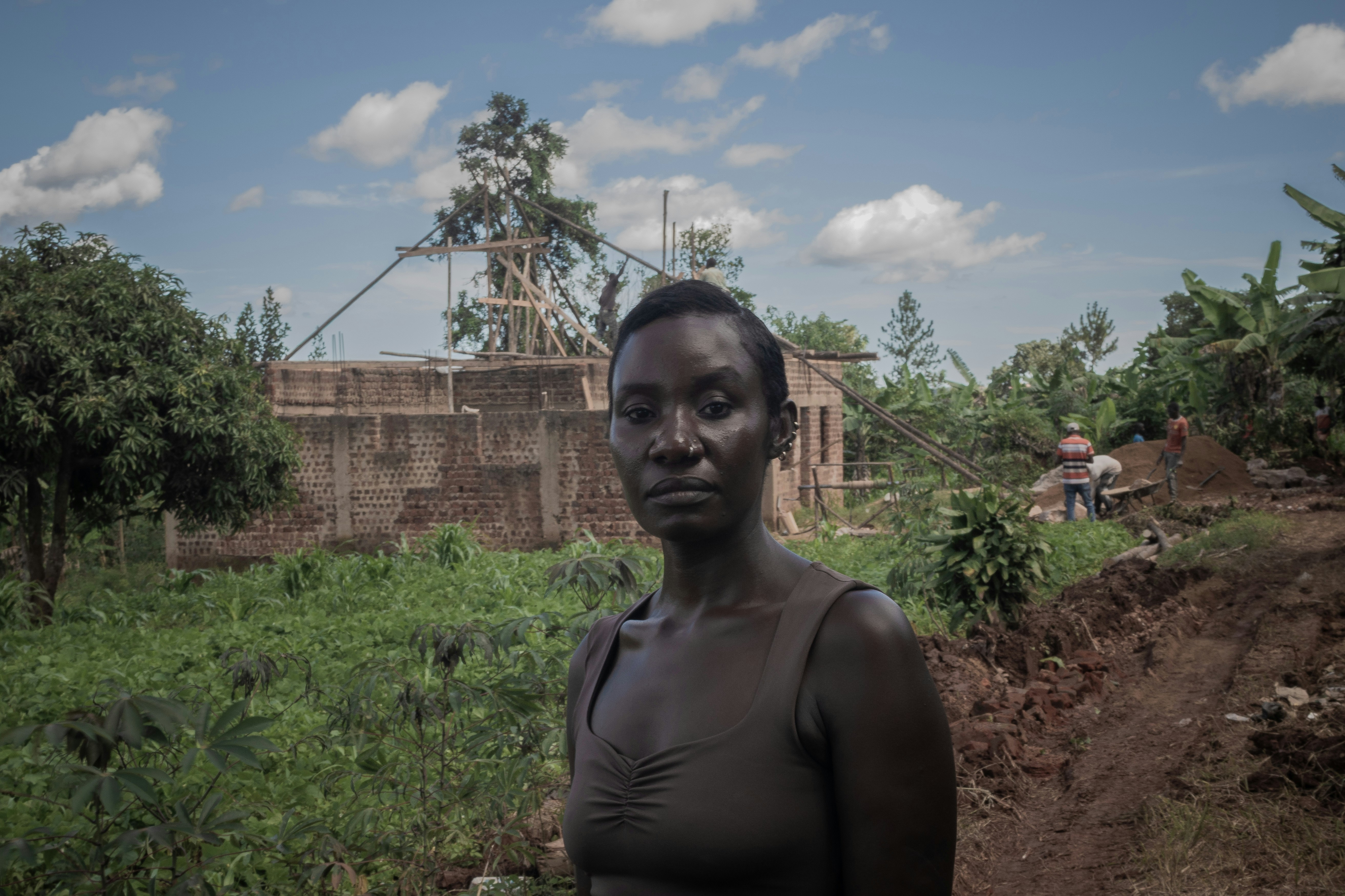 Une femme se tient devant un chantier.
