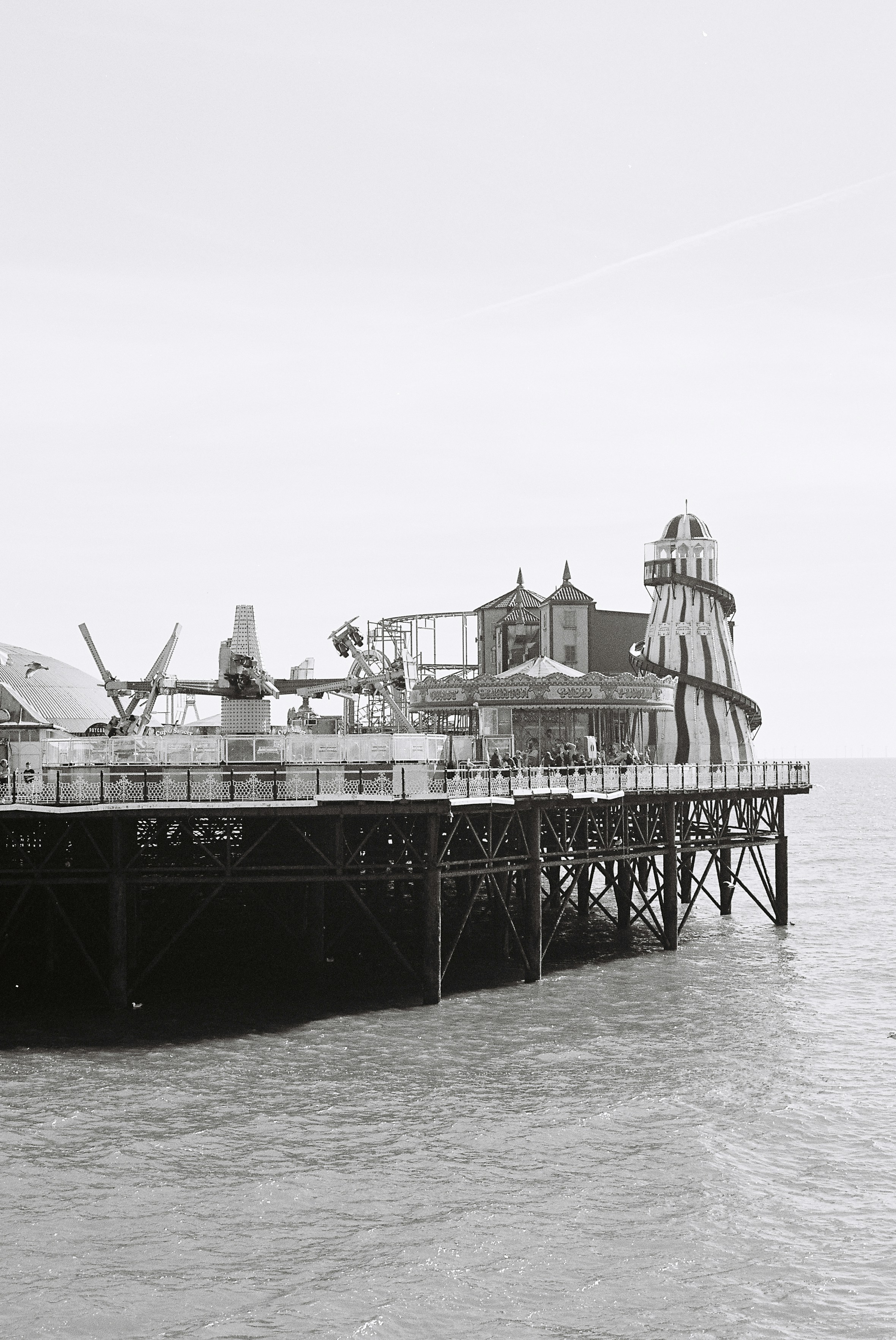 어트랙션이 있는 해변 부두의 흑백 모습.