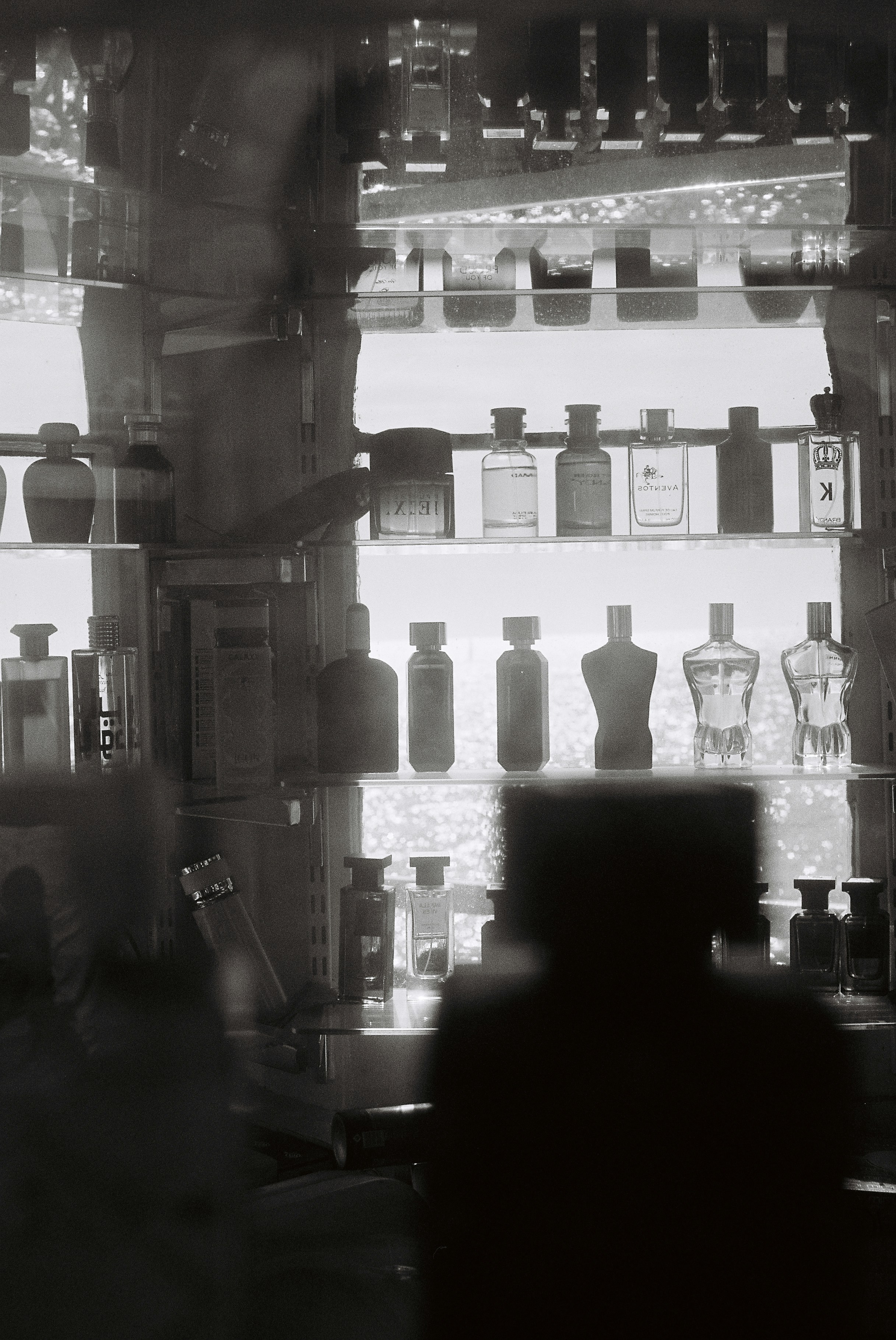 Botellas de perfume expuestas en estanterías de una tienda.