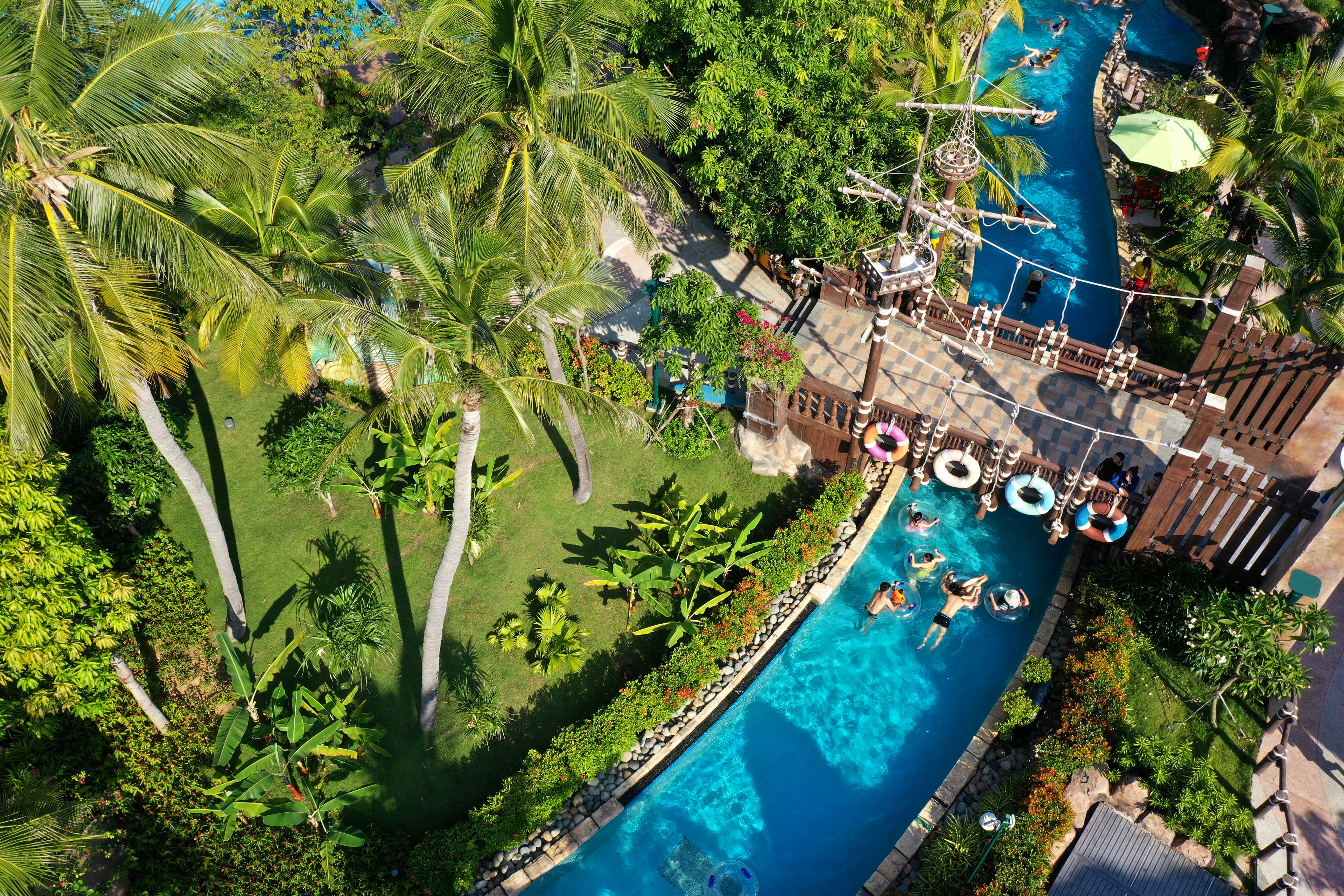 Visitors floating along a lazy river at a tropical water park