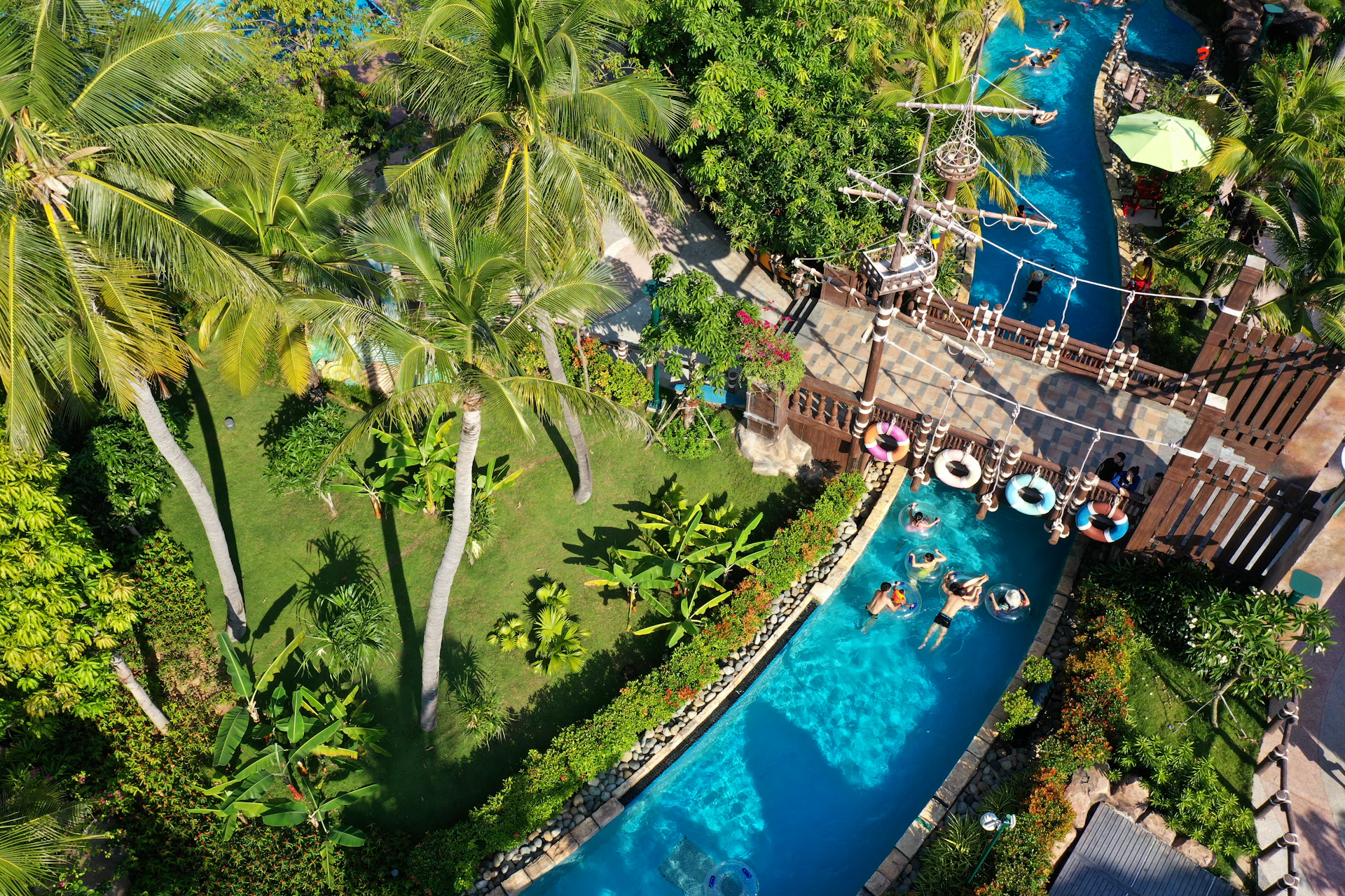 People floating in a lazy river at a tropical resort