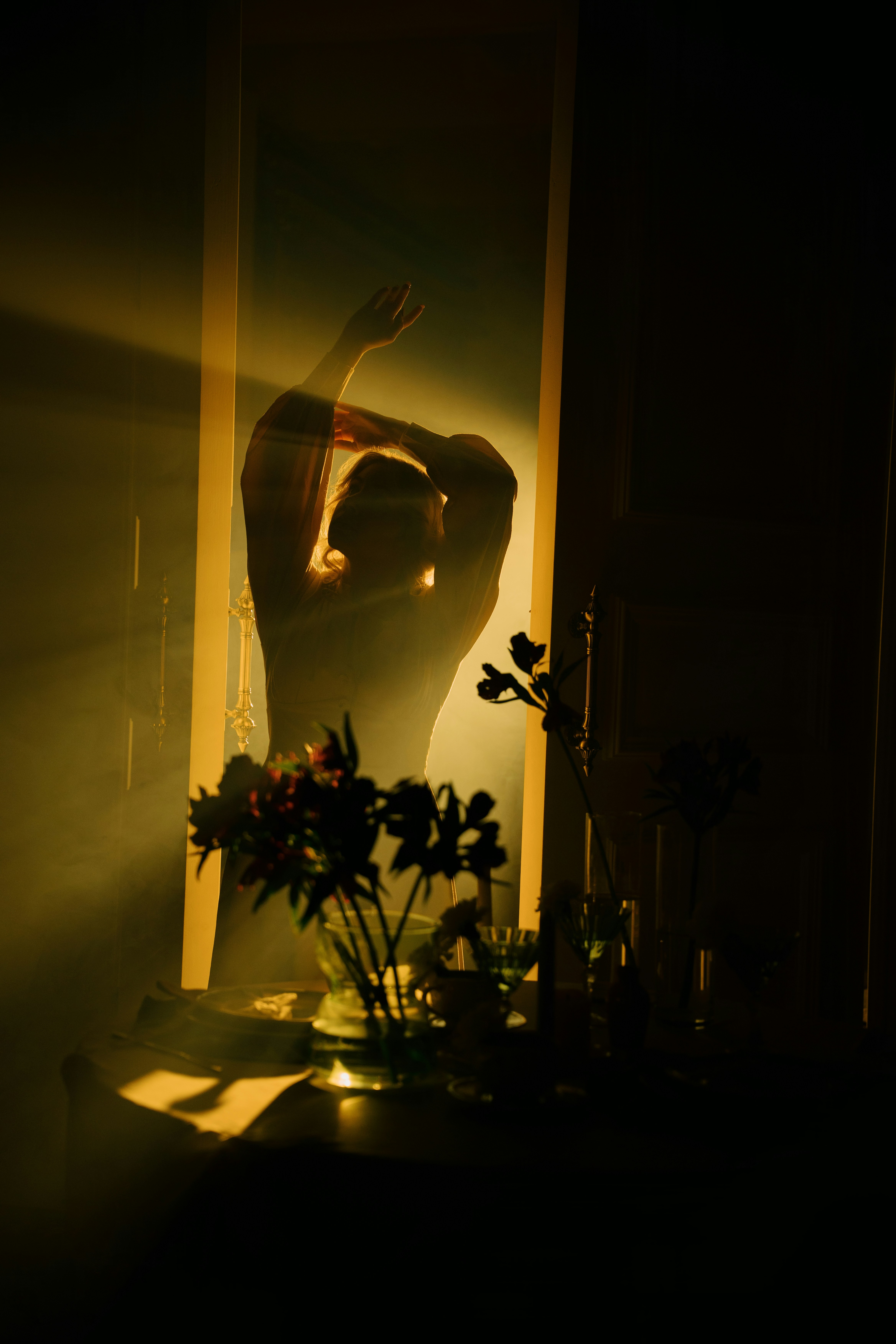 Silhouette of a person dancing in golden light.