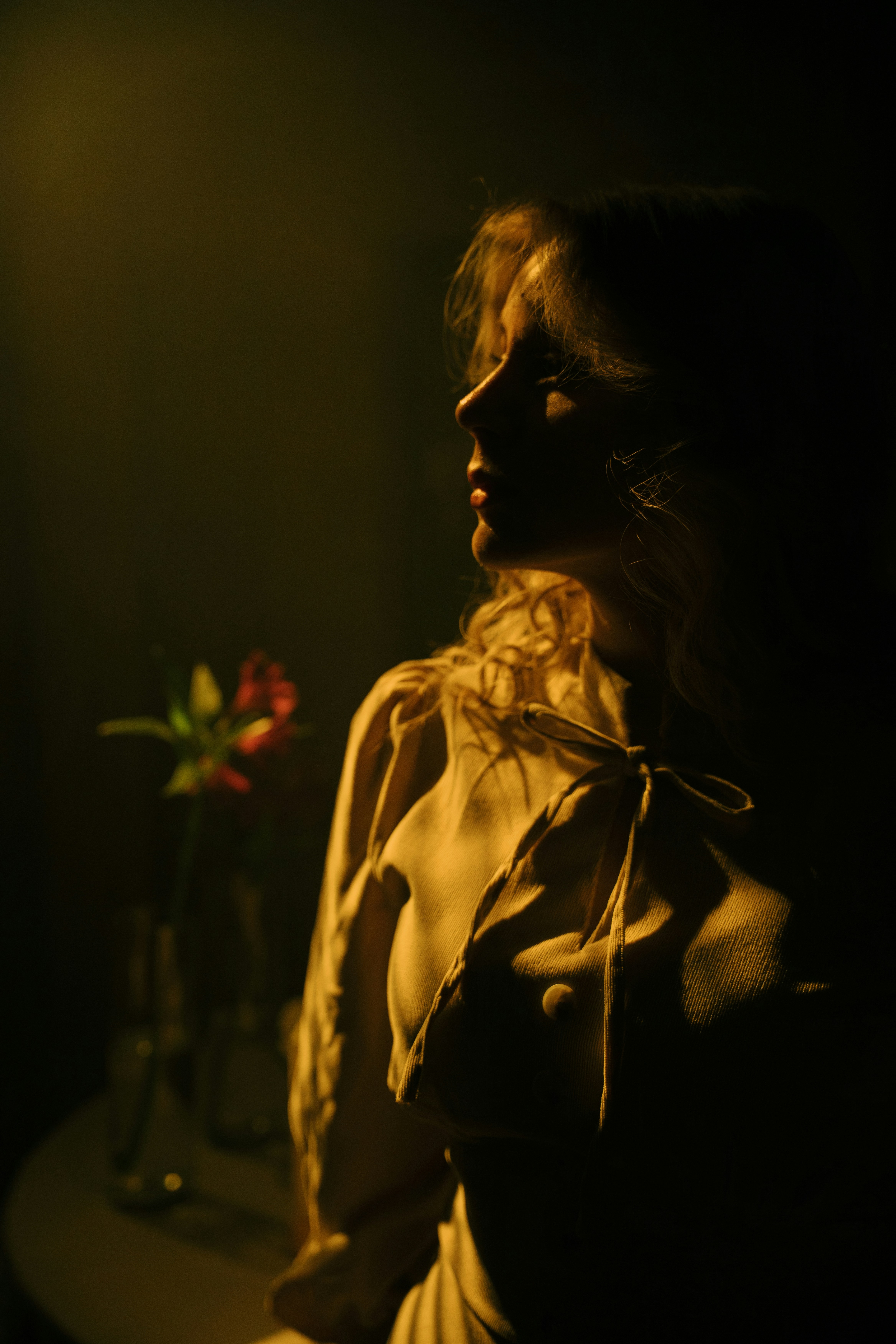 Mujer con vestido vintage y flores en un jarrón.