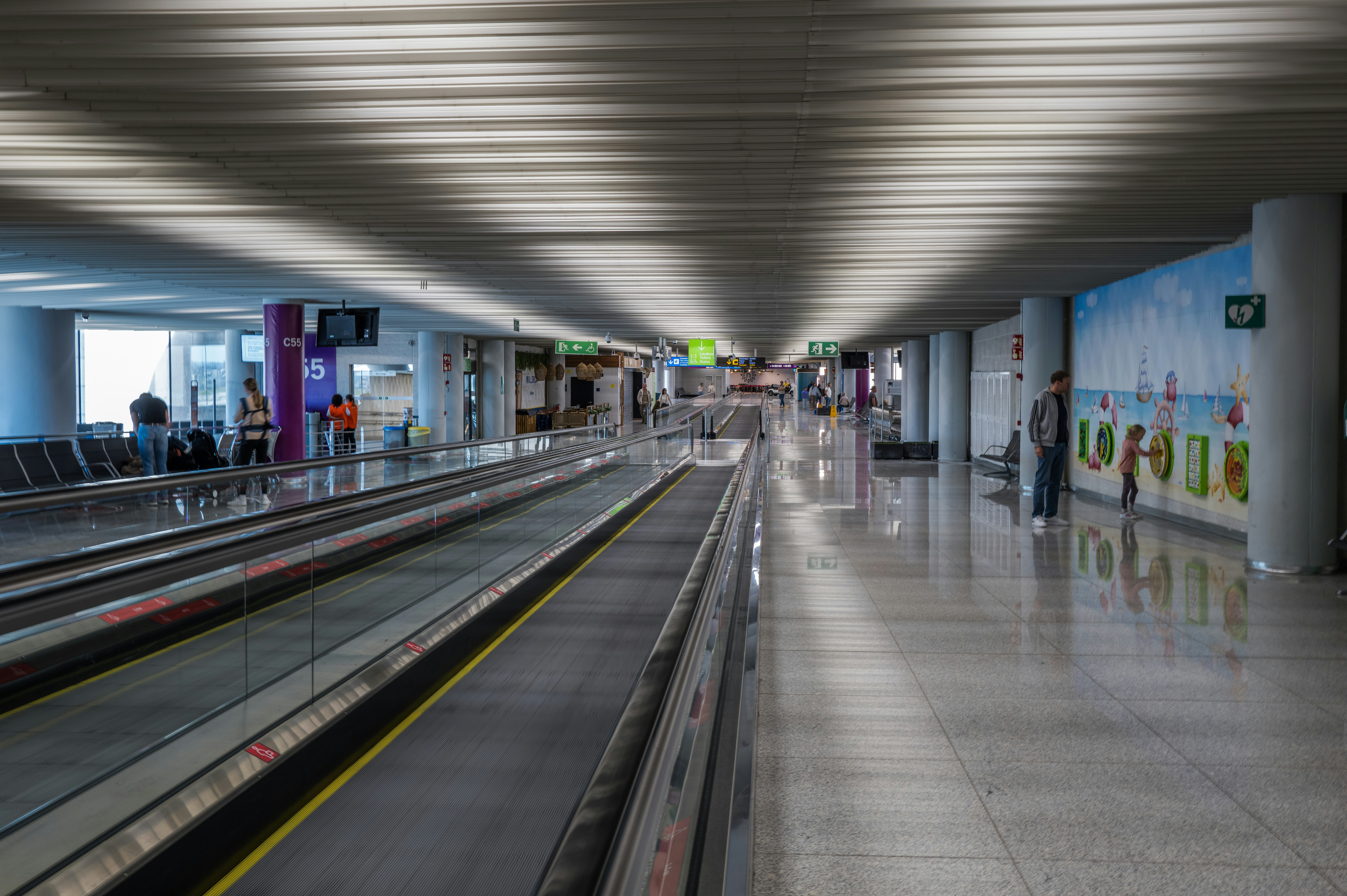 Terminal aeroportuale moderno con passaggio mobile e posti a sedere.