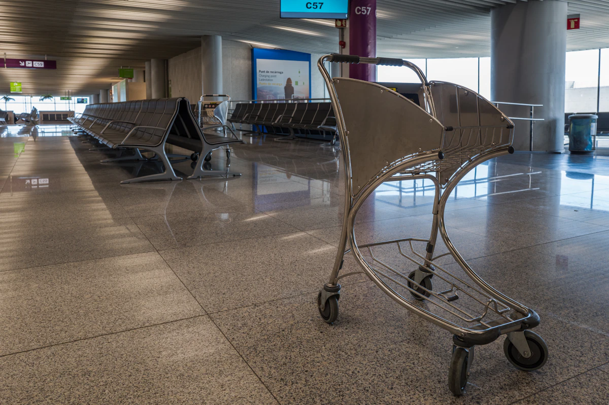 An empty luggage cart in an airport waiting area