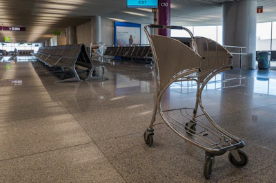 An empty luggage cart in an airport waiting area