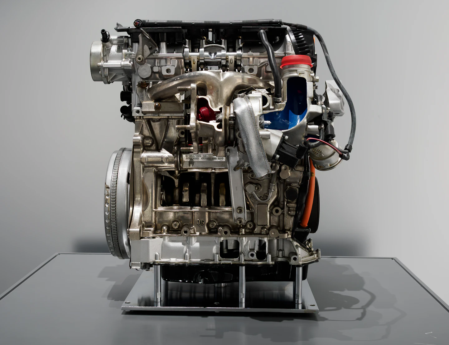 A cutaway engine on a display stand showing internal turbo plumbing and components