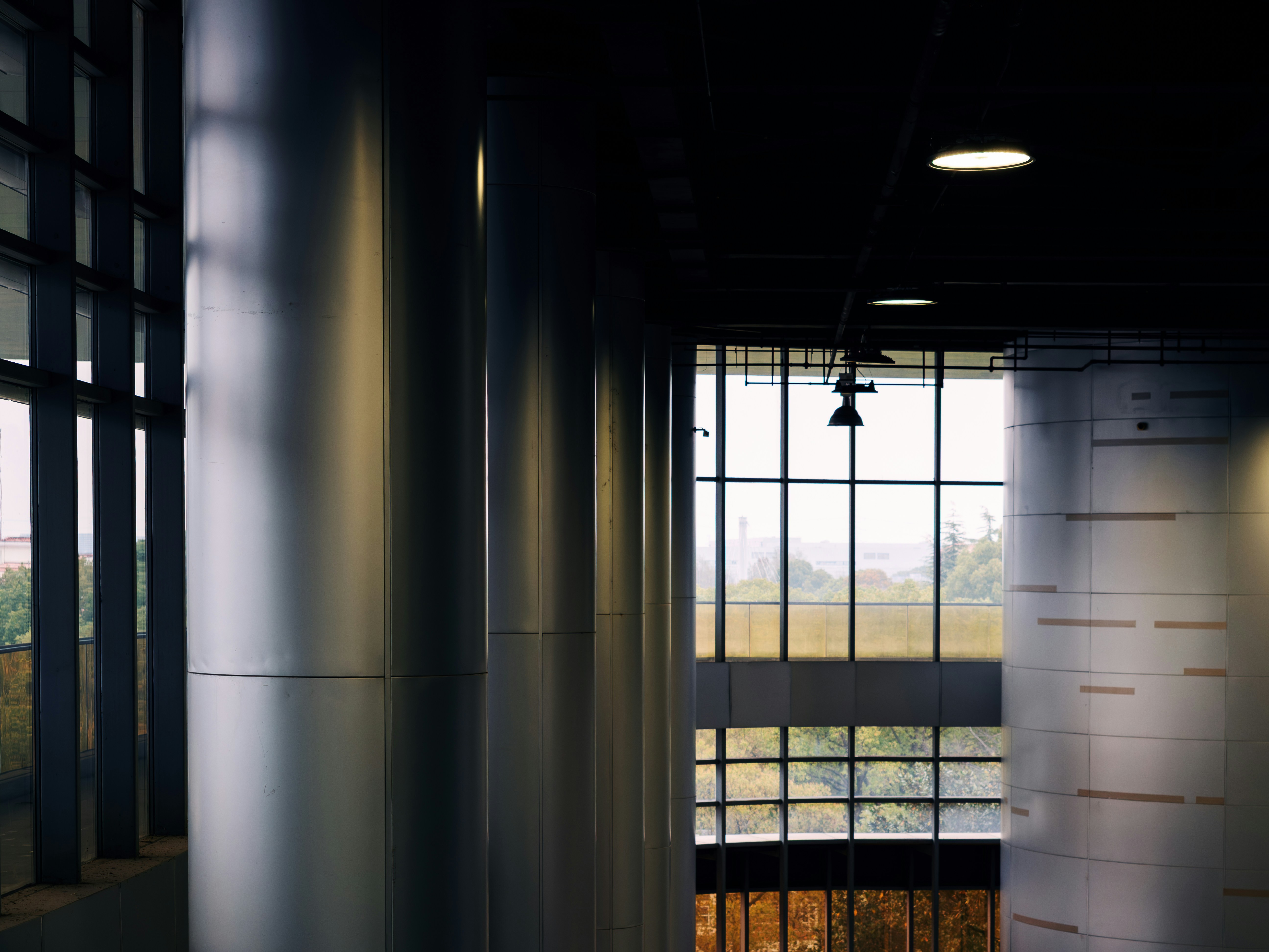 Modern building interior with large metallic columns and windows.