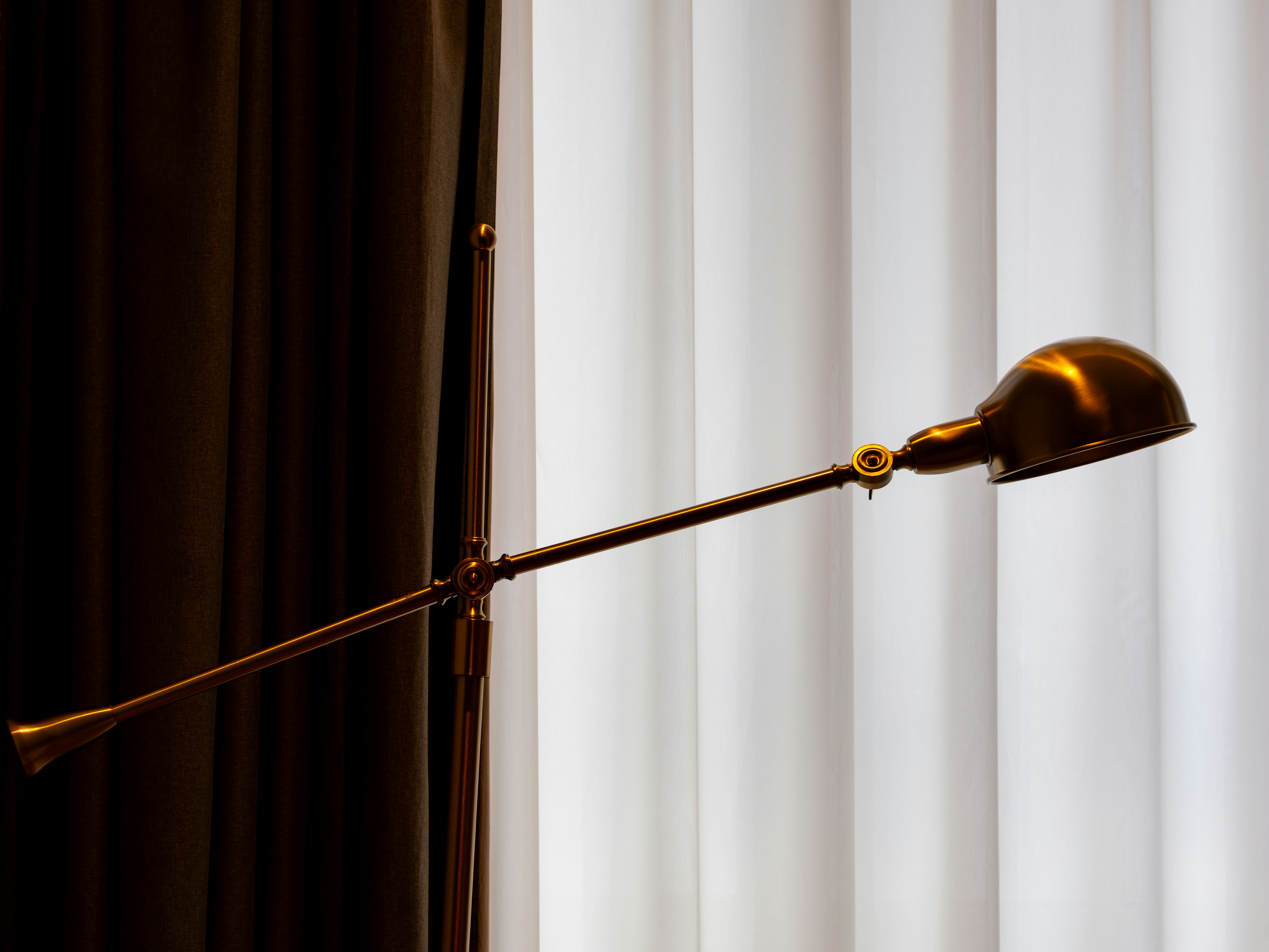 A brass desk lamp with adjustable arm.