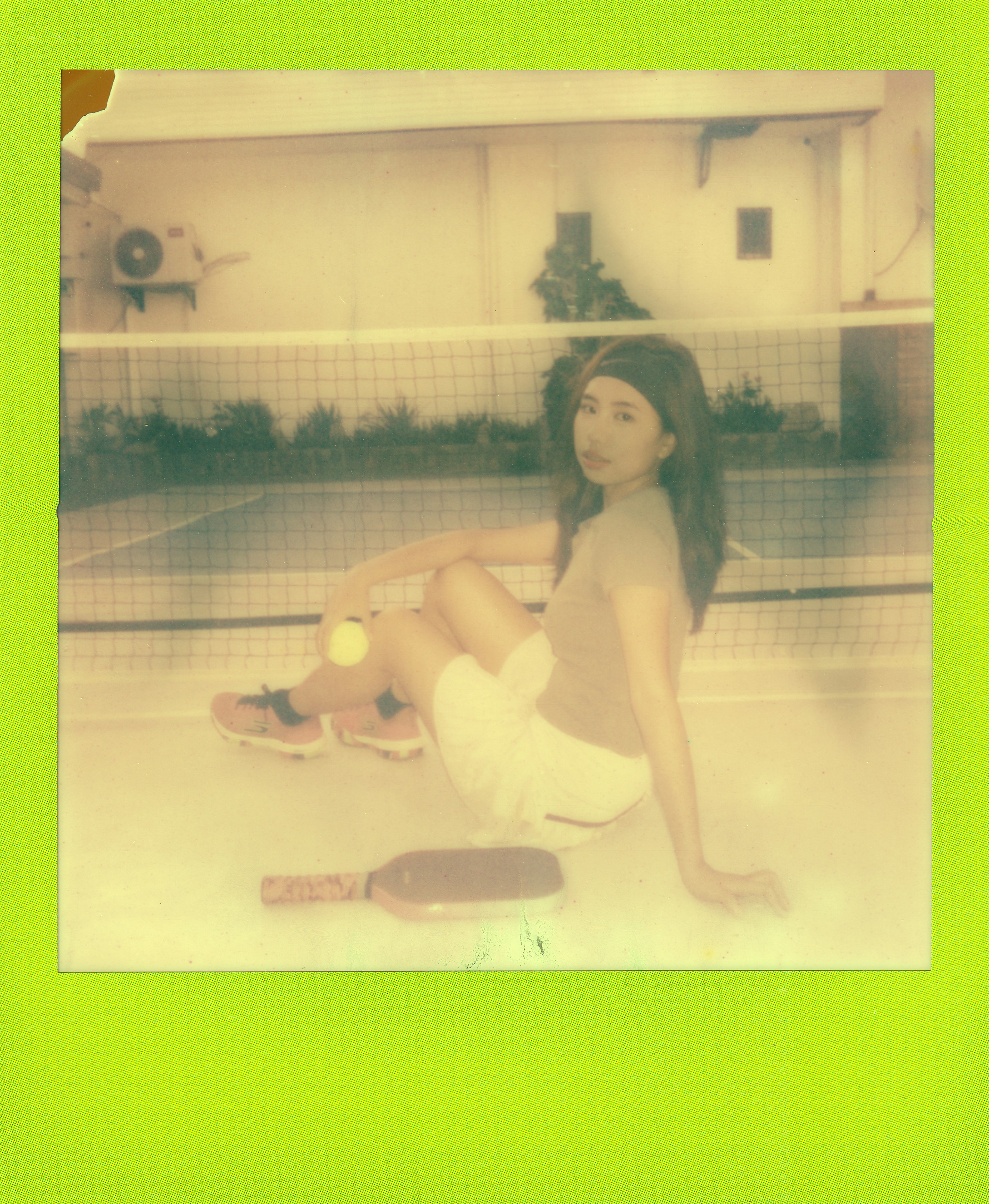 Wanita duduk di lapangan tenis dengan dayung