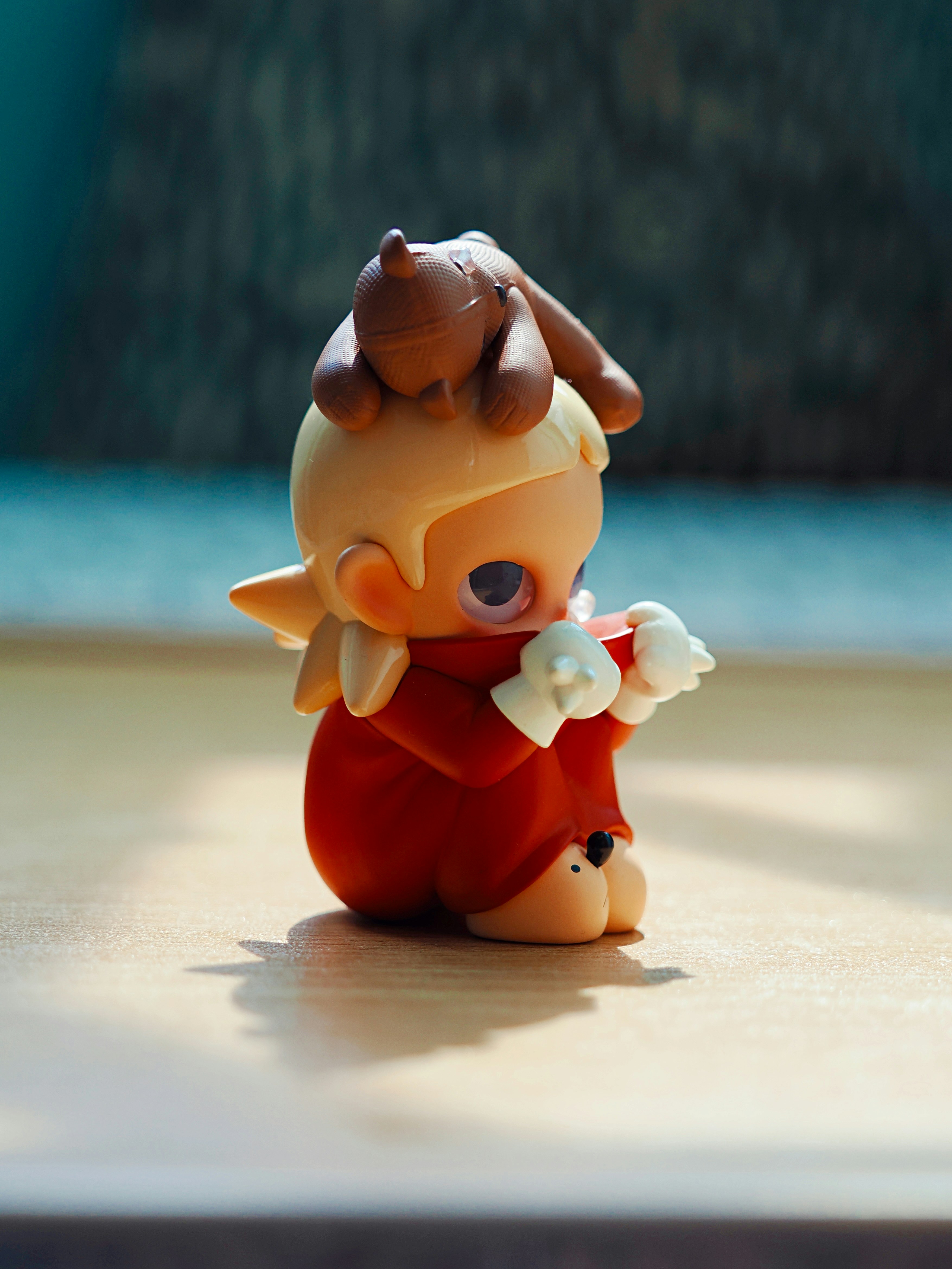 A small figurine with a brown dog on its head.