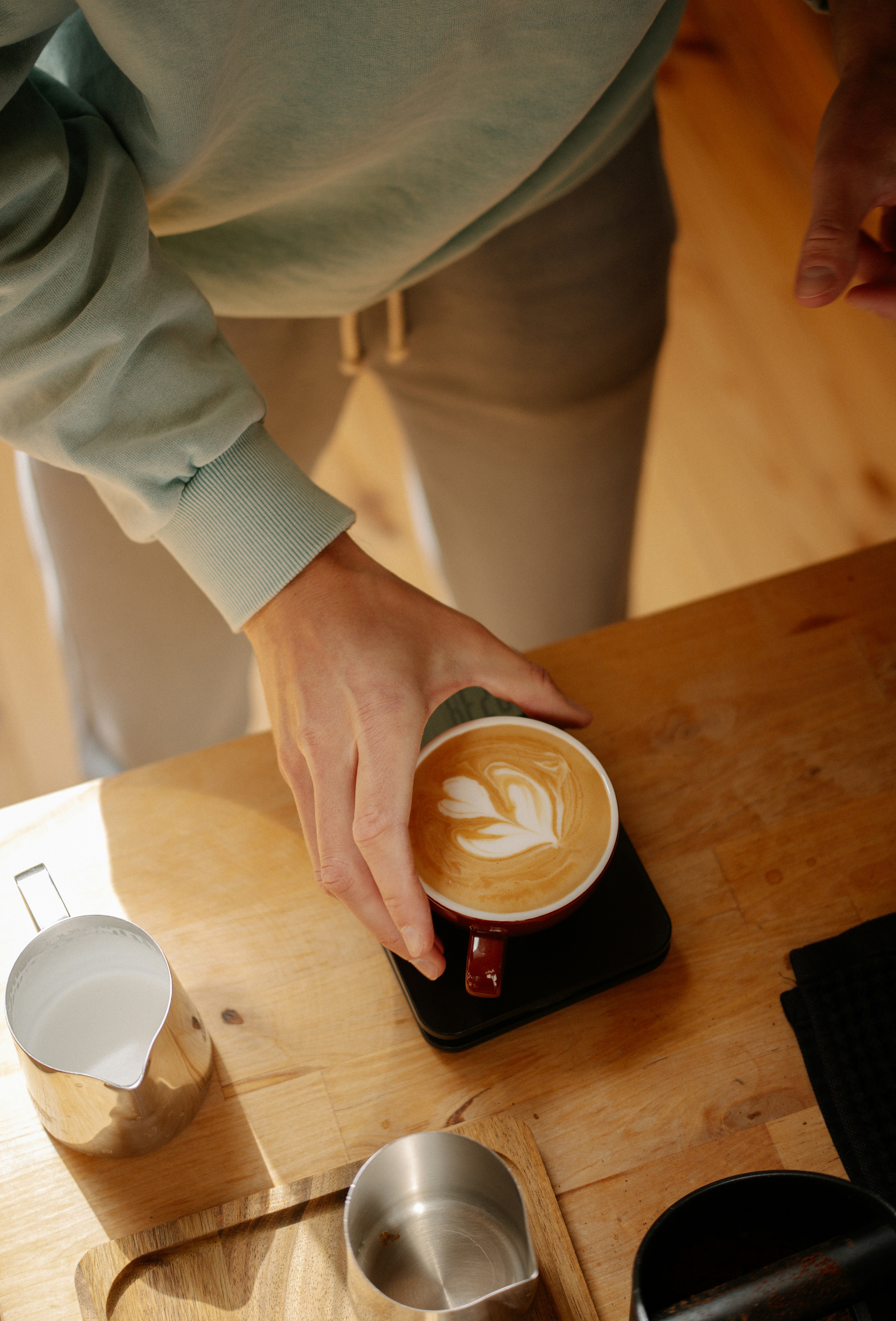 Barista creating latte art in a coffee cup