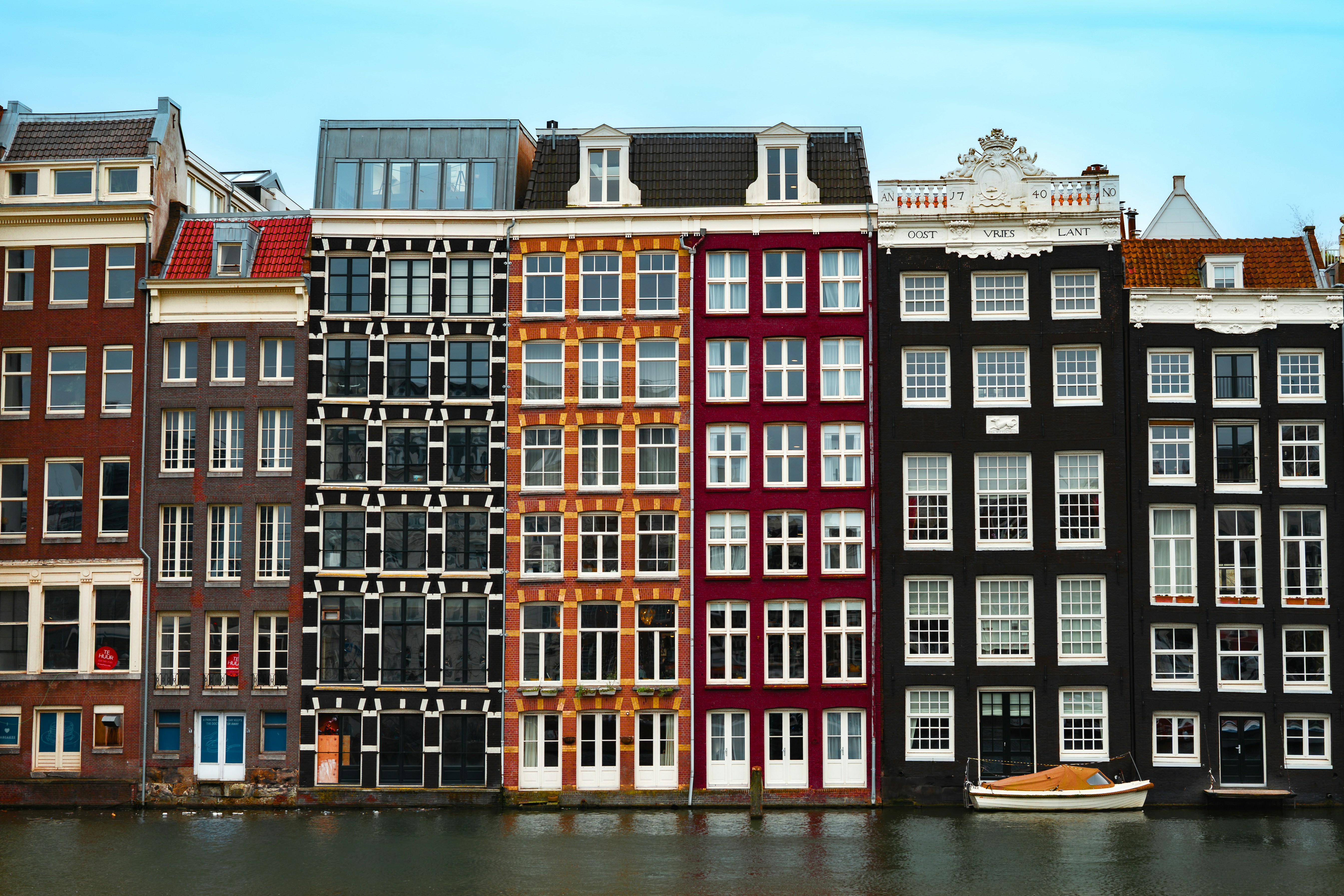 Colorful buildings line a canal with a small boat.
