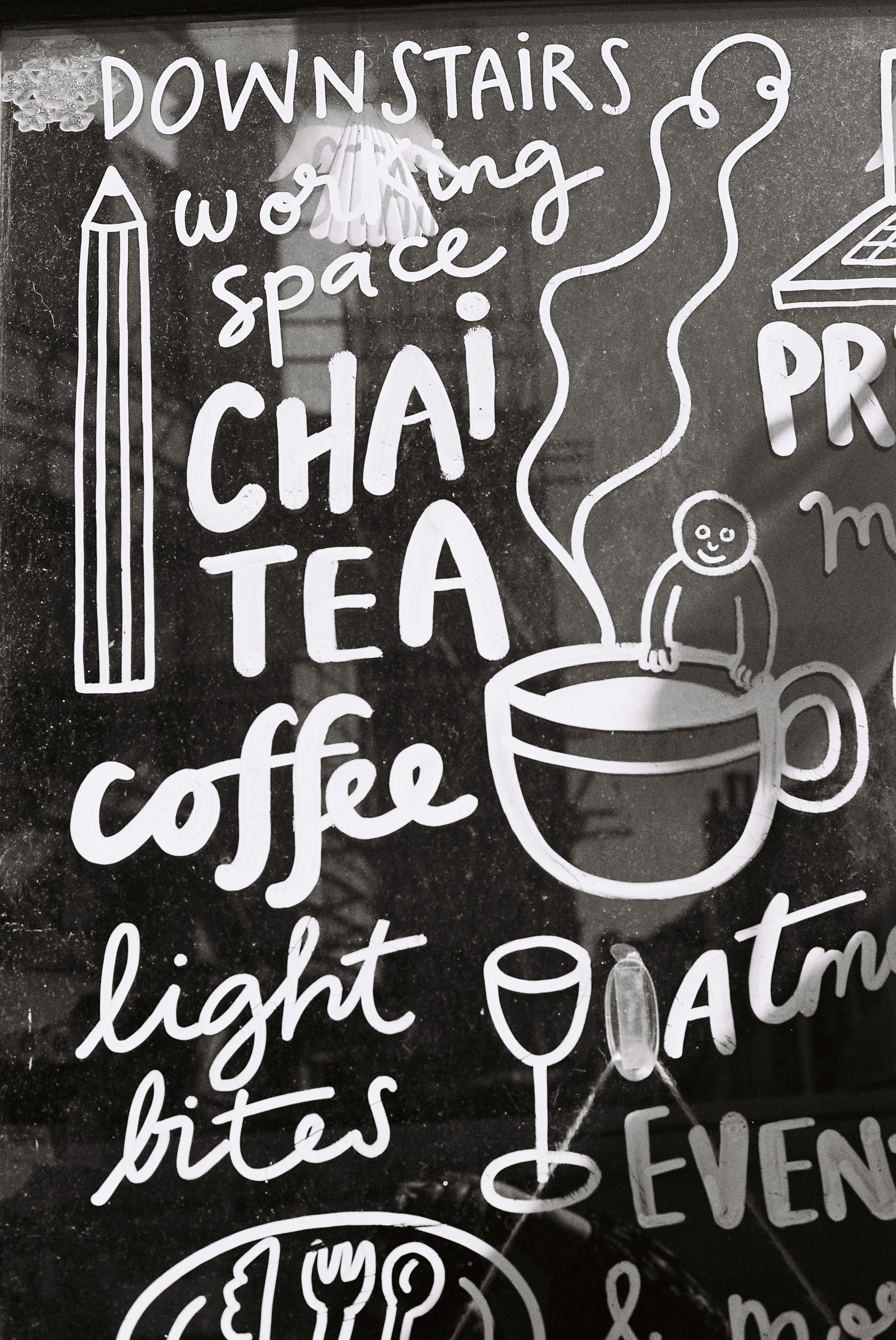 칠판에 커피, 차, 가벼운 간식 메뉴가 담겨 있습니다