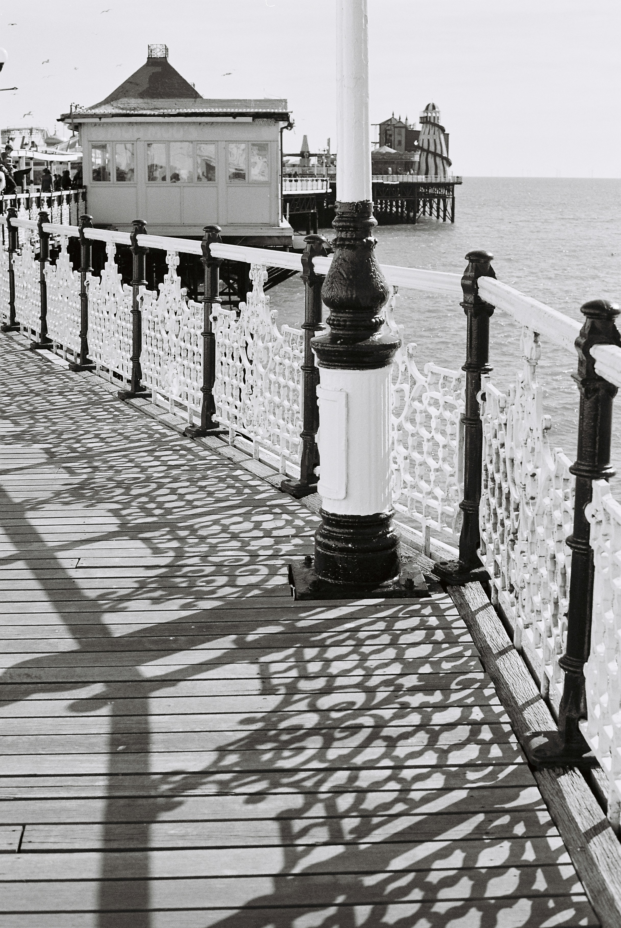 화려한 난간이 나무 부두에 그림자를 드리웁니다.