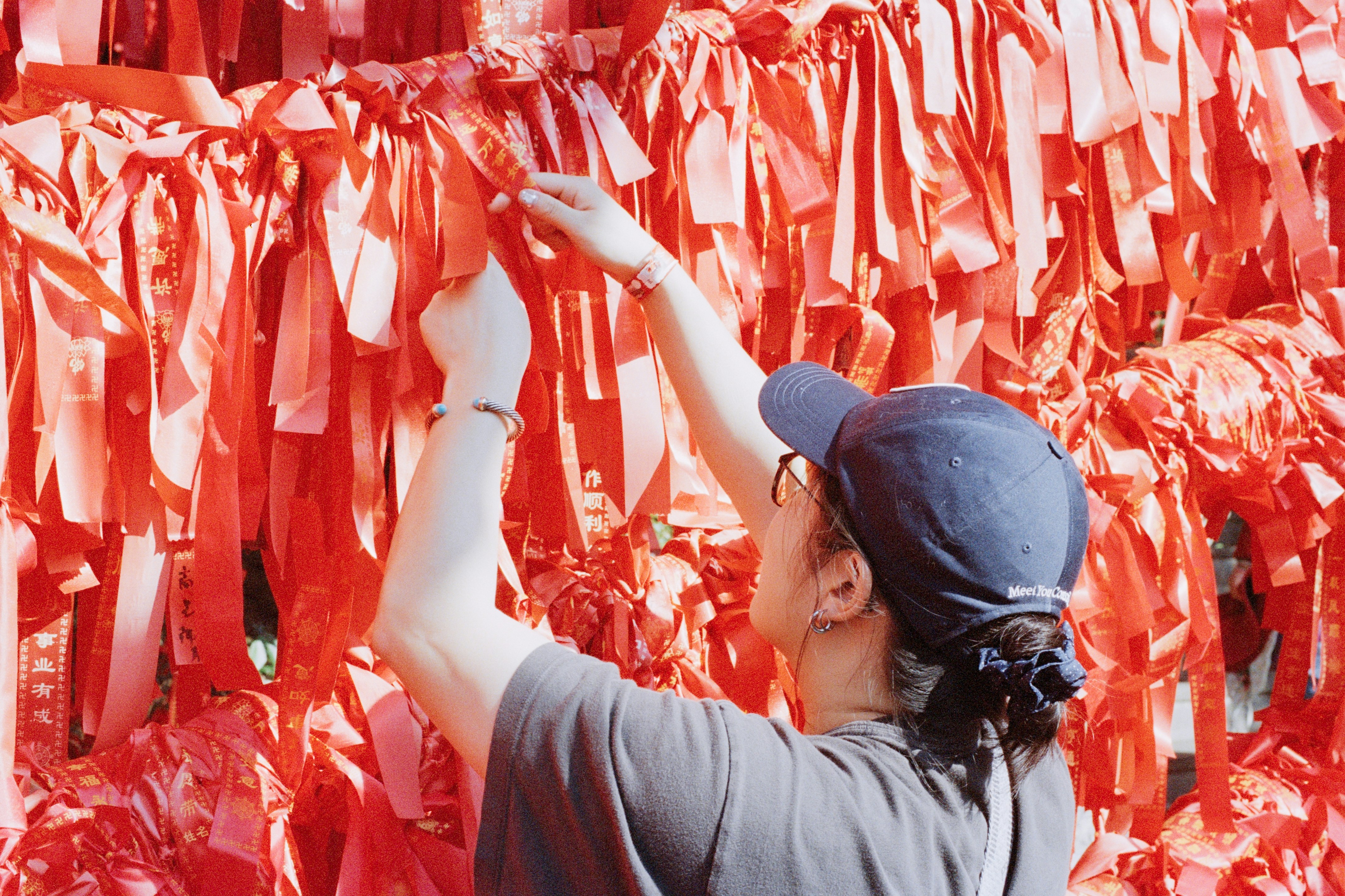 Uma pessoa prende uma fita vermelha em uma parede.
