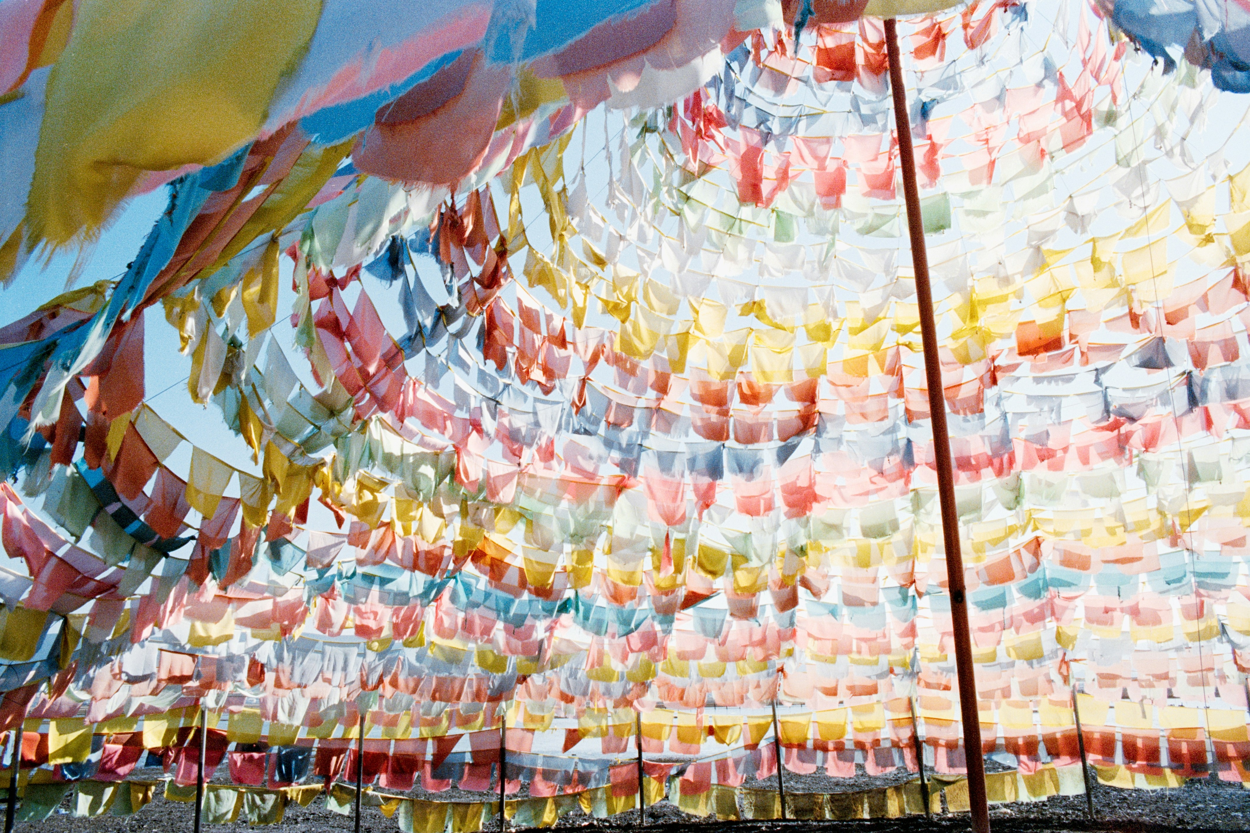 Bunte Gebetsfahnen, die über einen blauen Himmel gespannt sind