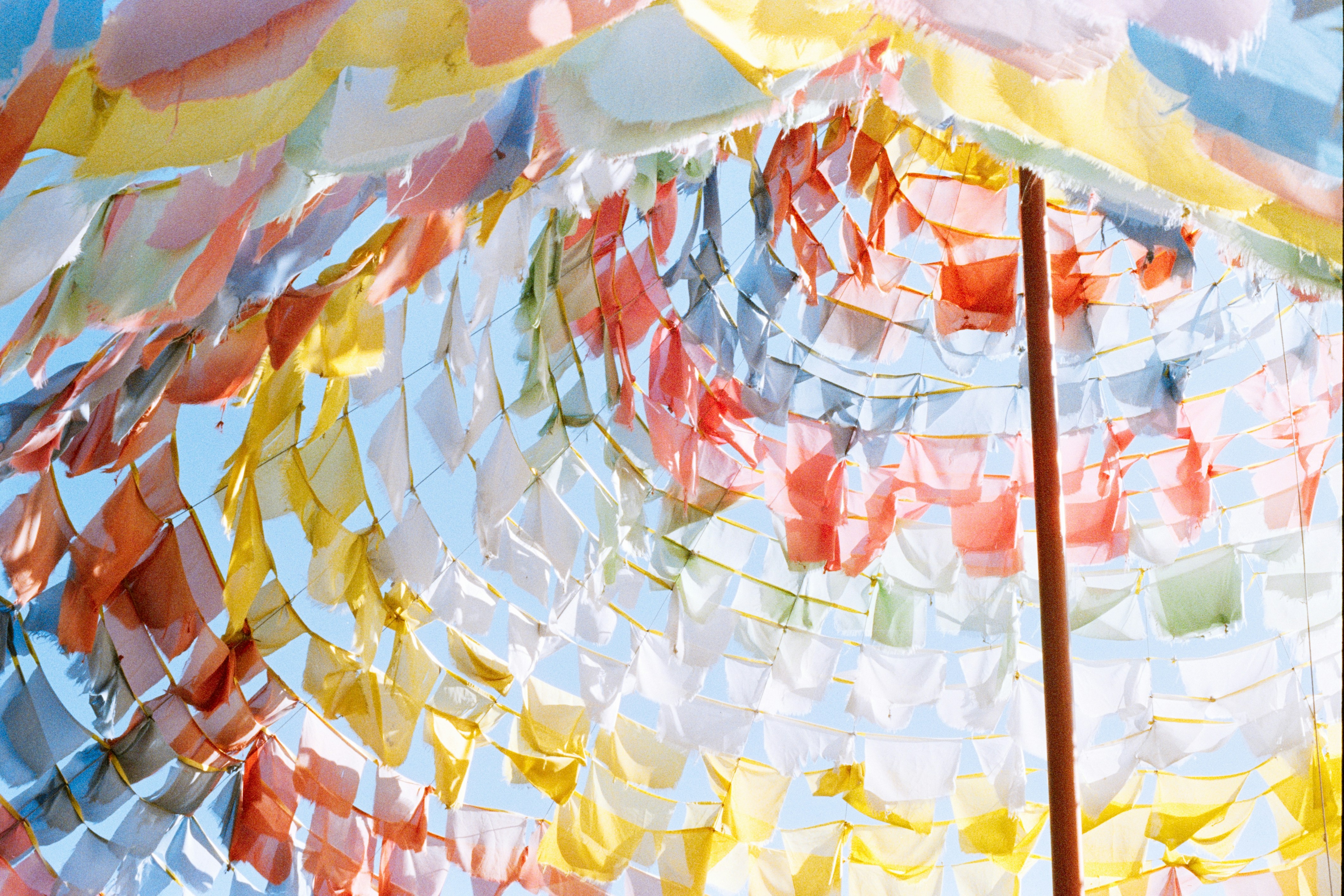 Colorful prayer flags strung across a clear sky.