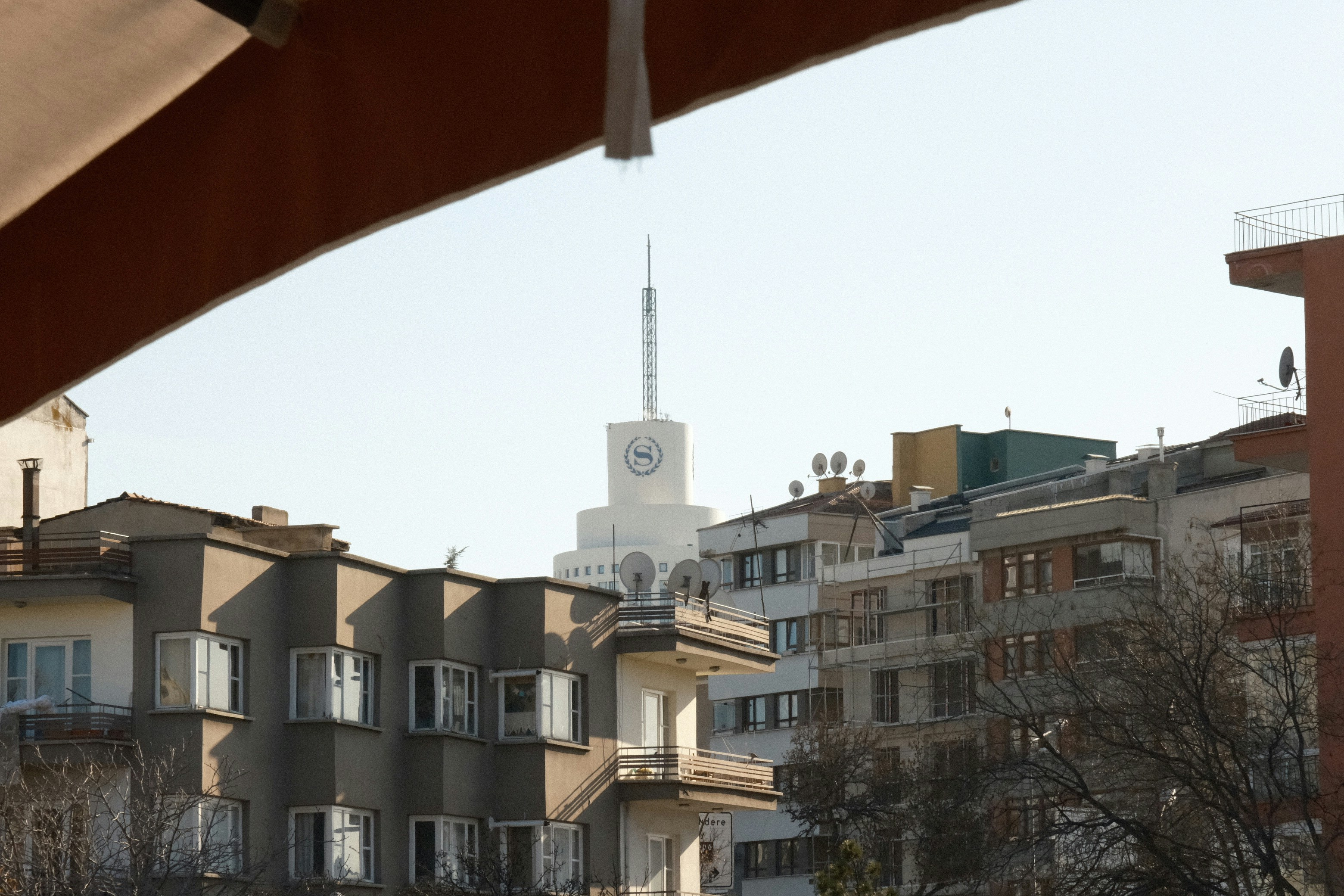Ein weißer Turm mit Uhr steht über den Stadtgebäuden.