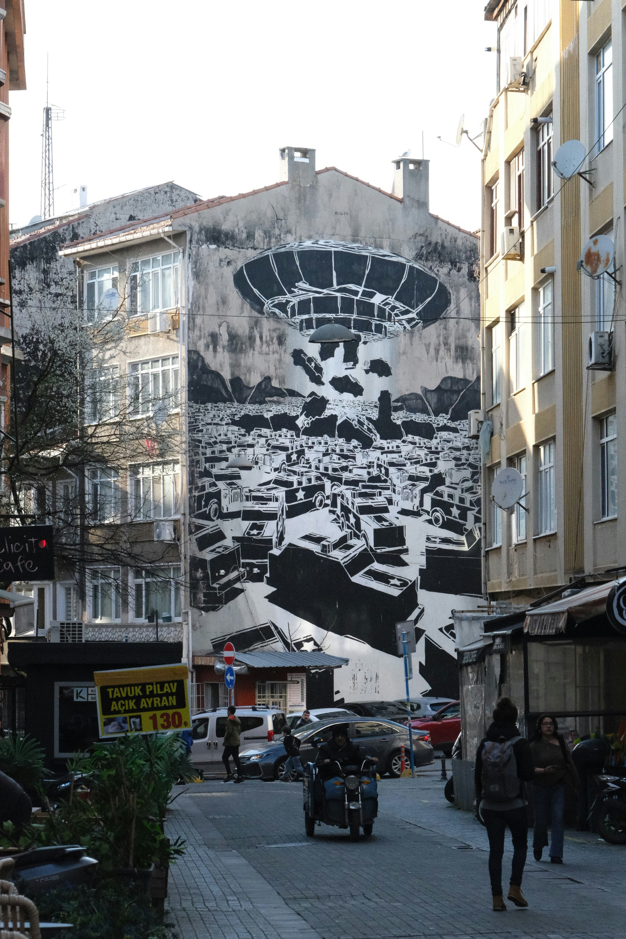 Wandgemälde eines UFOs, das über einer Stadt schwebt