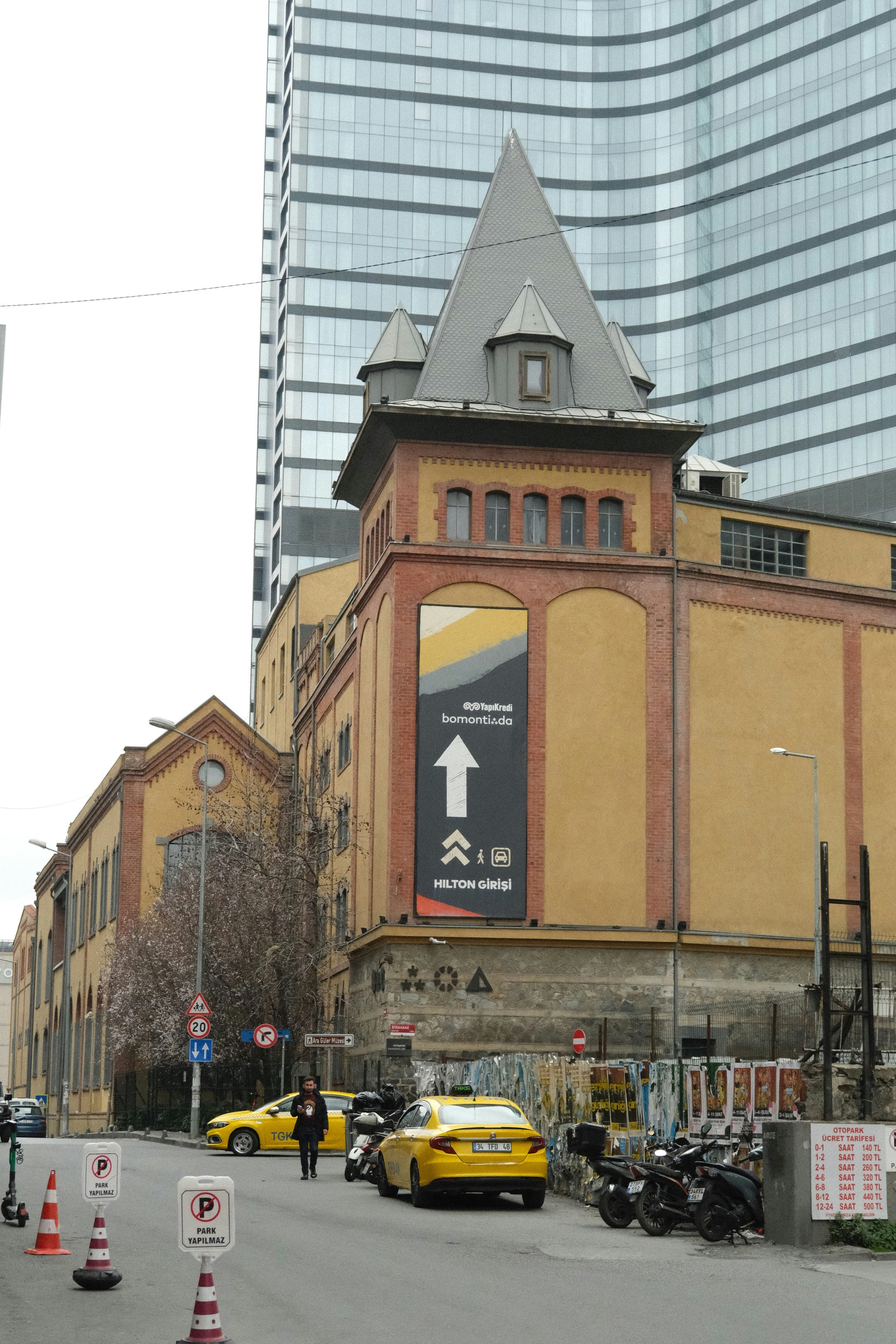 Gelbe Autos parkten auf der Straße in der Nähe eines Backsteingebäudes und Wolkenkratzers