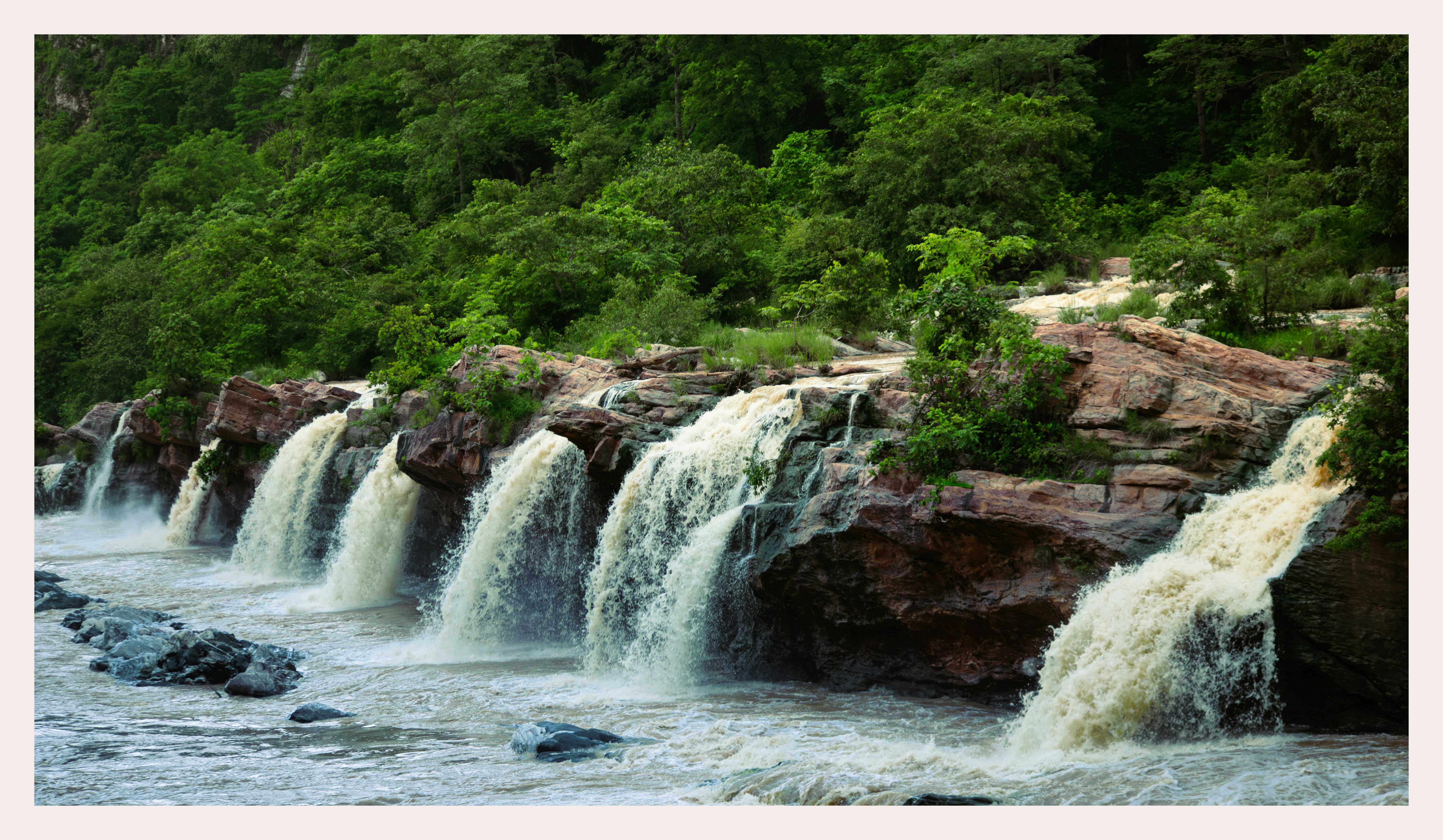 A series of waterfalls cascades over rocky ledges.