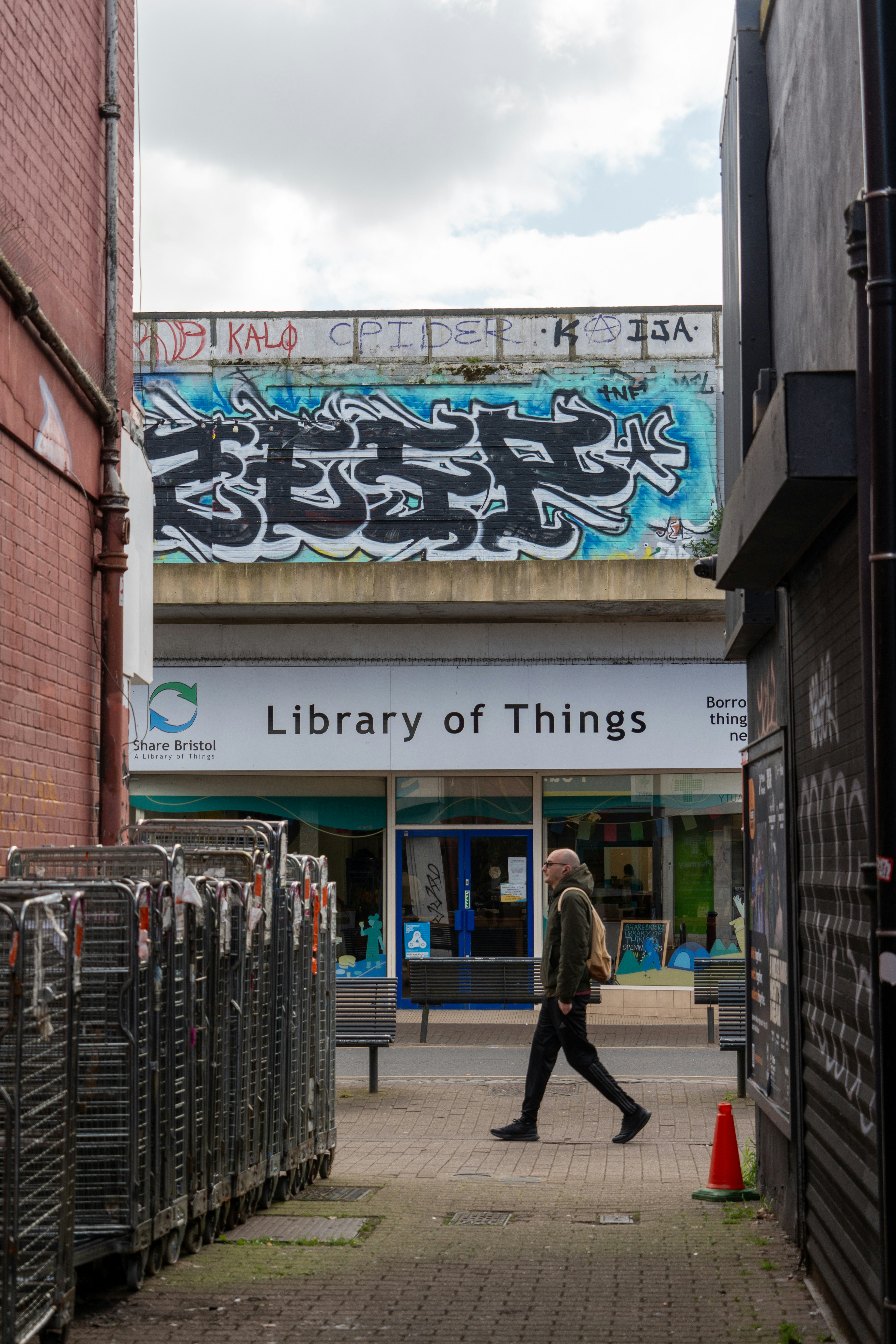 Person geht an einer Bibliothek voller Dinge mit Graffiti vorbei