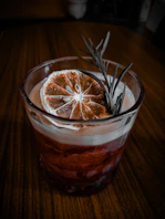 Cocktail with dried orange slice and rosemary garnish