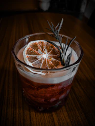Cocktail with dried orange slice and rosemary garnish