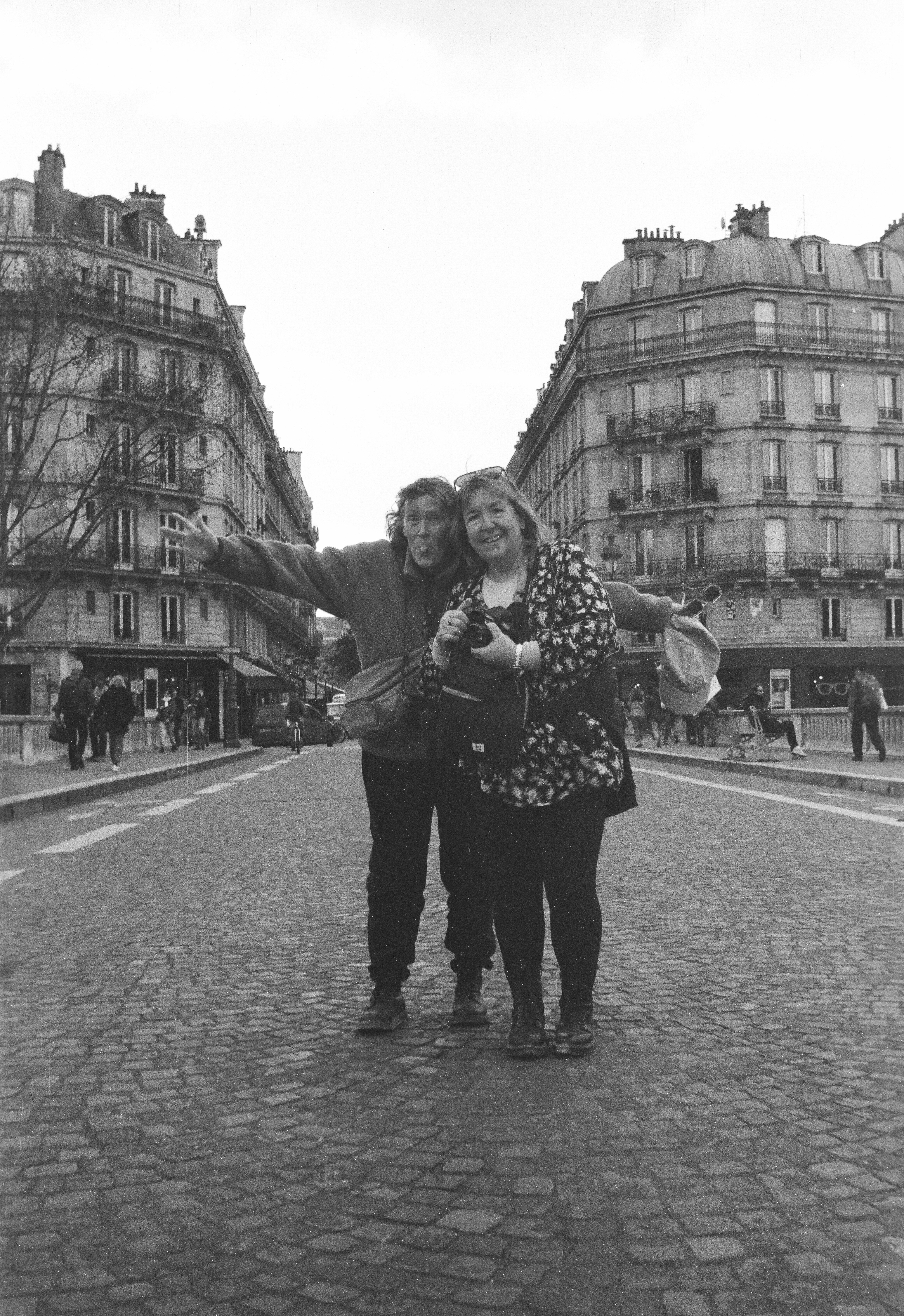 Due donne in piedi su una strada ciottolata a Parigi.